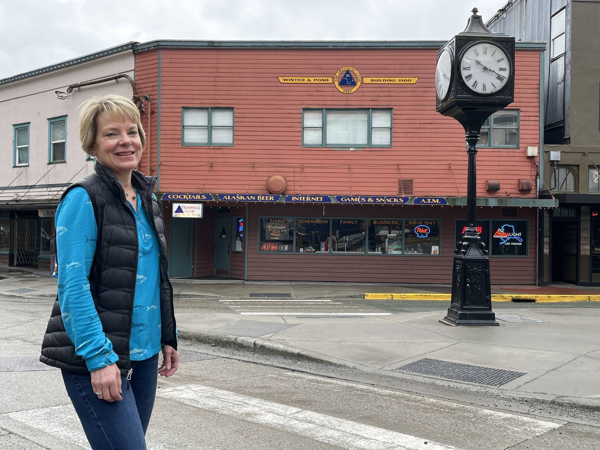 Leeann Thomas, third-generation owner of the Triangle Club, stands before the business her grandfather started in 1947. The location has a long history of Juneau businesses. (Laurie Craig / For the Downtown Business Association)