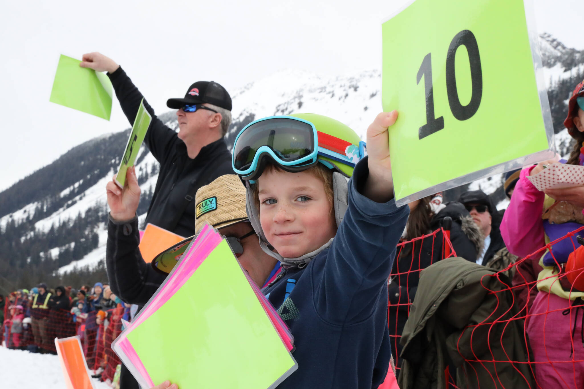 Slush Cup judge Corbin Hall, 7, gives his mom a perfect score as she glides over the pond Saturday afternoon. (Clarise Larson / Juneau Empire)