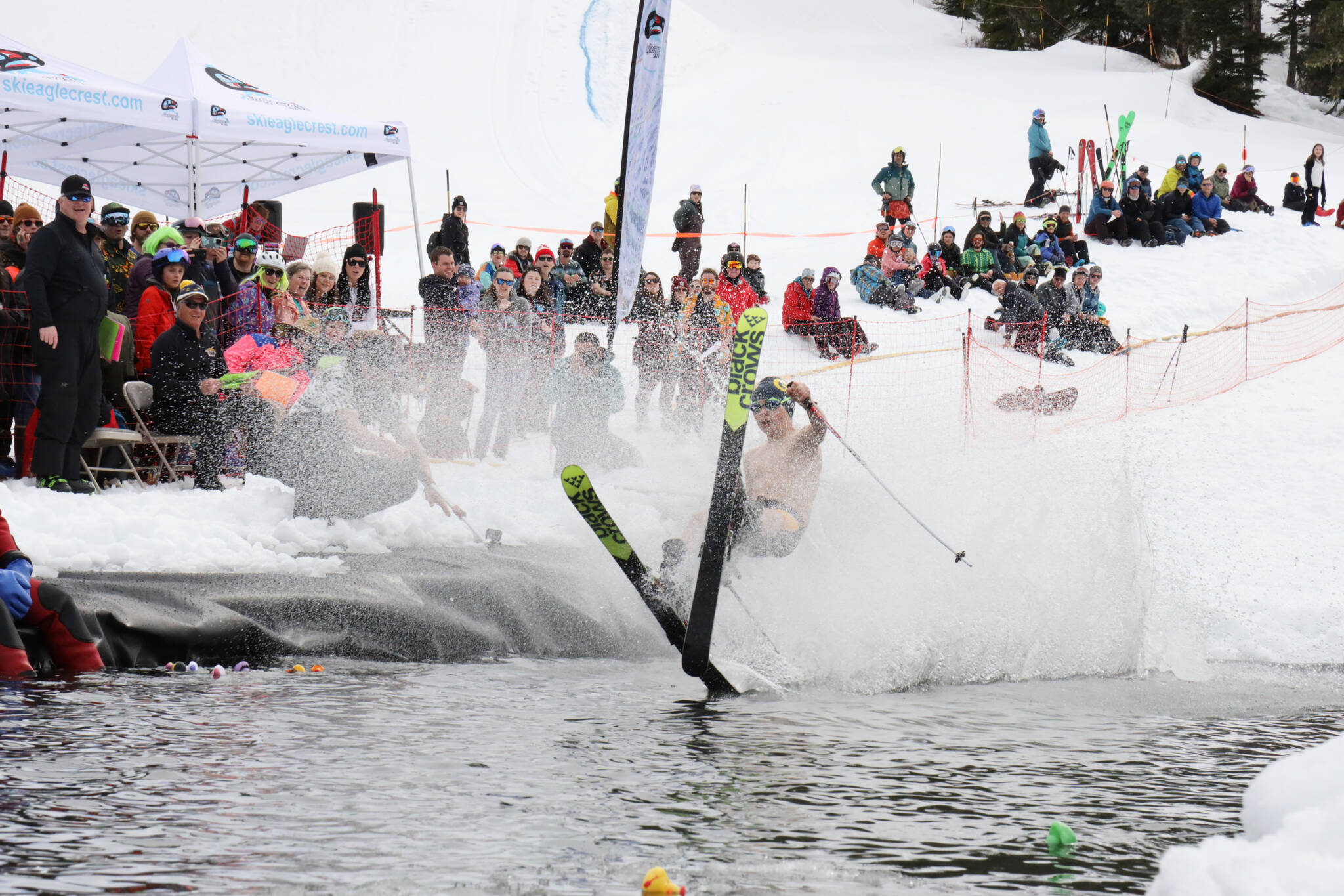 A skier makes a crash landing into the skim pond at Eaglecrest Ski Area as they partake in the return of the Slush Cup Saturday afternoon. (Clarise Larson / Juneau Empire)