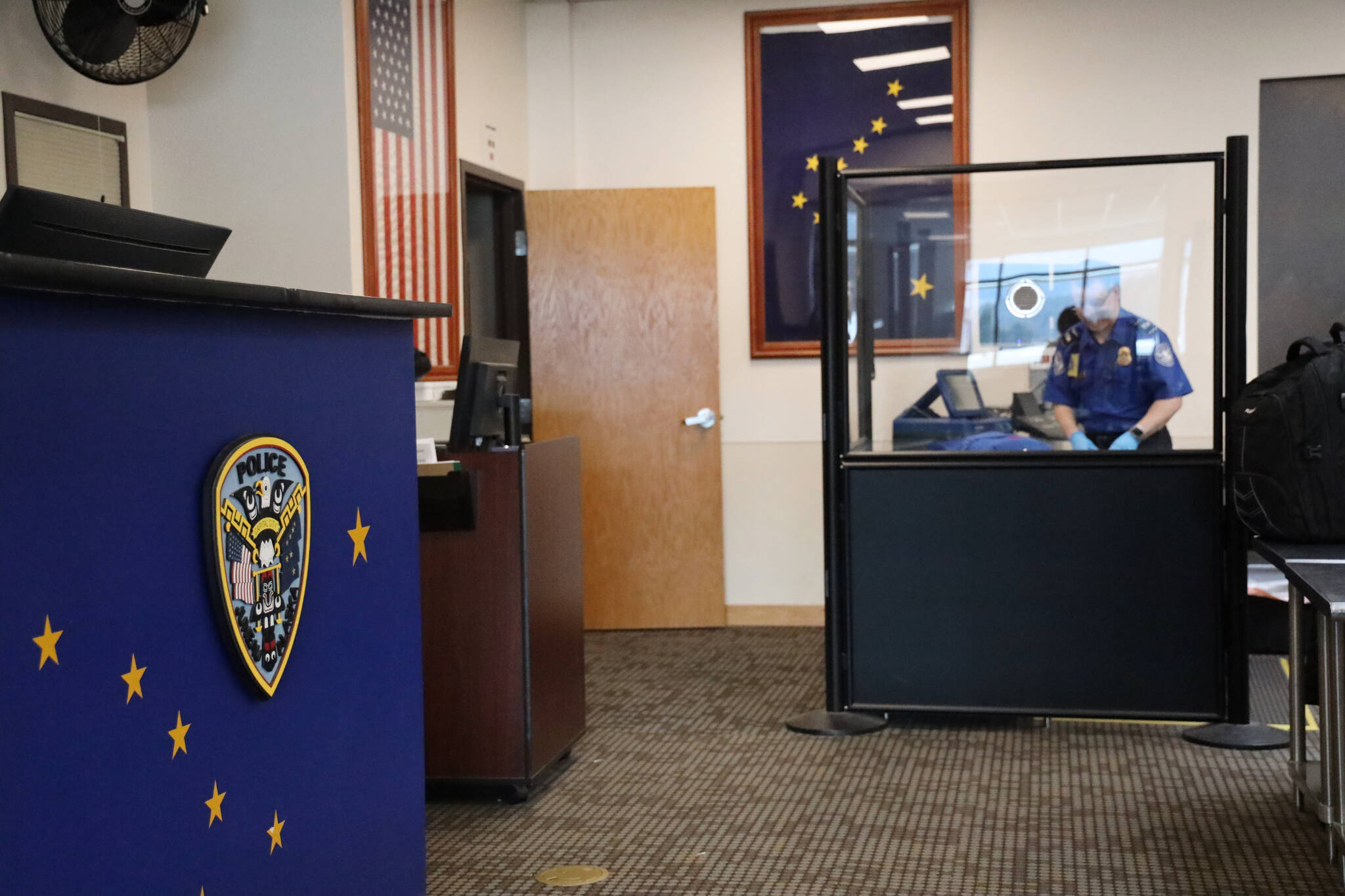 A Transportation Security Administration officer checks luggage at the Juneau International Airport in March. (Clarise Larson / Juneau Empire File)