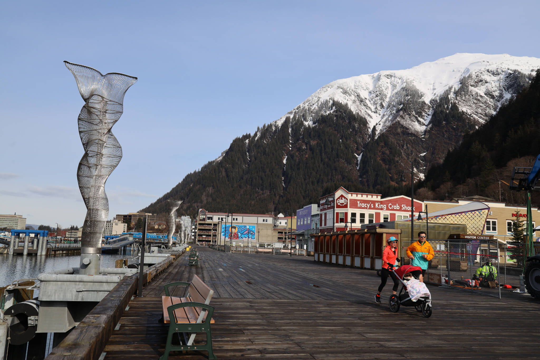 Residents jog along the downtown cruise ship docks Friday morning. Downtown is about to become much busier starting Monday as Juneau welcomes the first cruise ship of the 2023 season. (Clarise Larson / Juneau Empire)