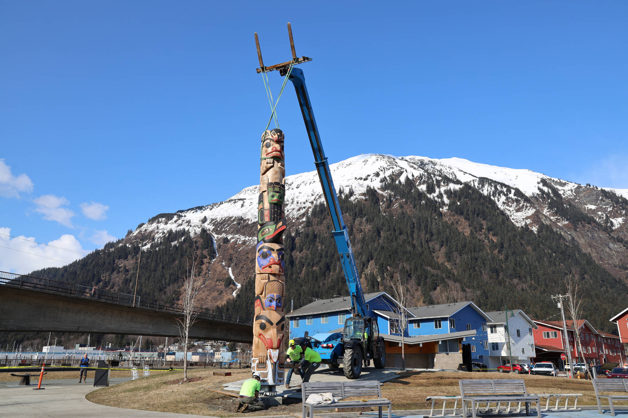 A crane slowly raises a totem pole by Tsimshian carver Gyibaawm Laxha David Robert Boxley at Overstreet Park Sunday afternoon. The pole is one of the first 12 of 30 totem poles to be raised to create a Kootéeyaa Deiyí (totem pole trail) lining the waterfront in Juneau. (Clarise Larson / Juneau Empire)