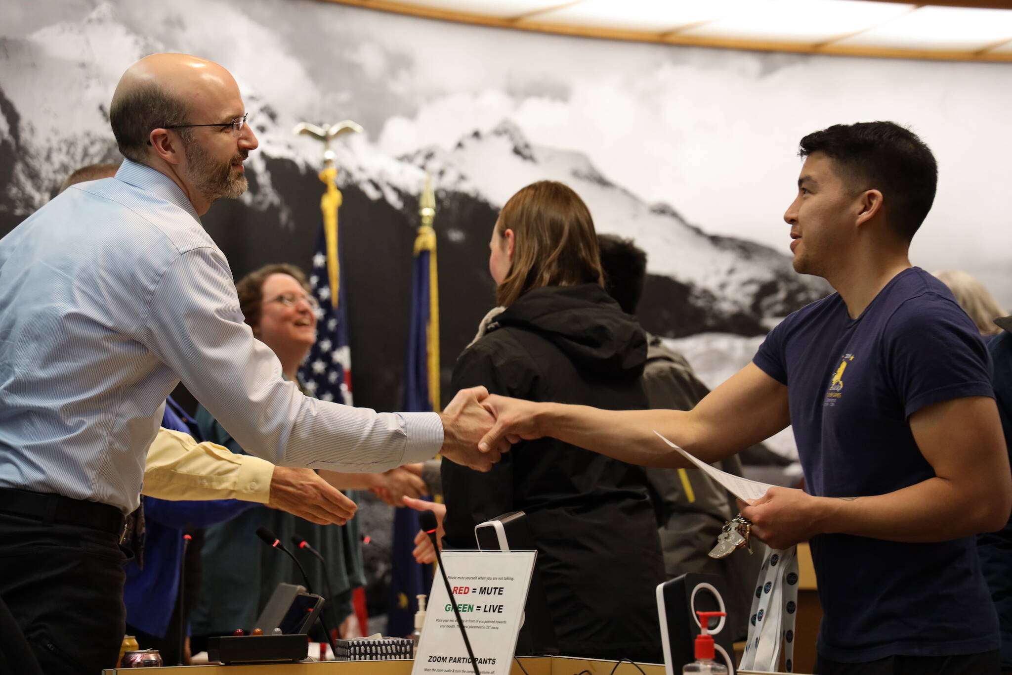 Kyle Khaayák’w Worl, an athlete and coach for Team Alaska at the 2023 Arctic Winter Games in February, shakes hands with City and Borough of Juneau Deputy City Manager Robert Barr Monday night. Worl competed in Arctic Sports.