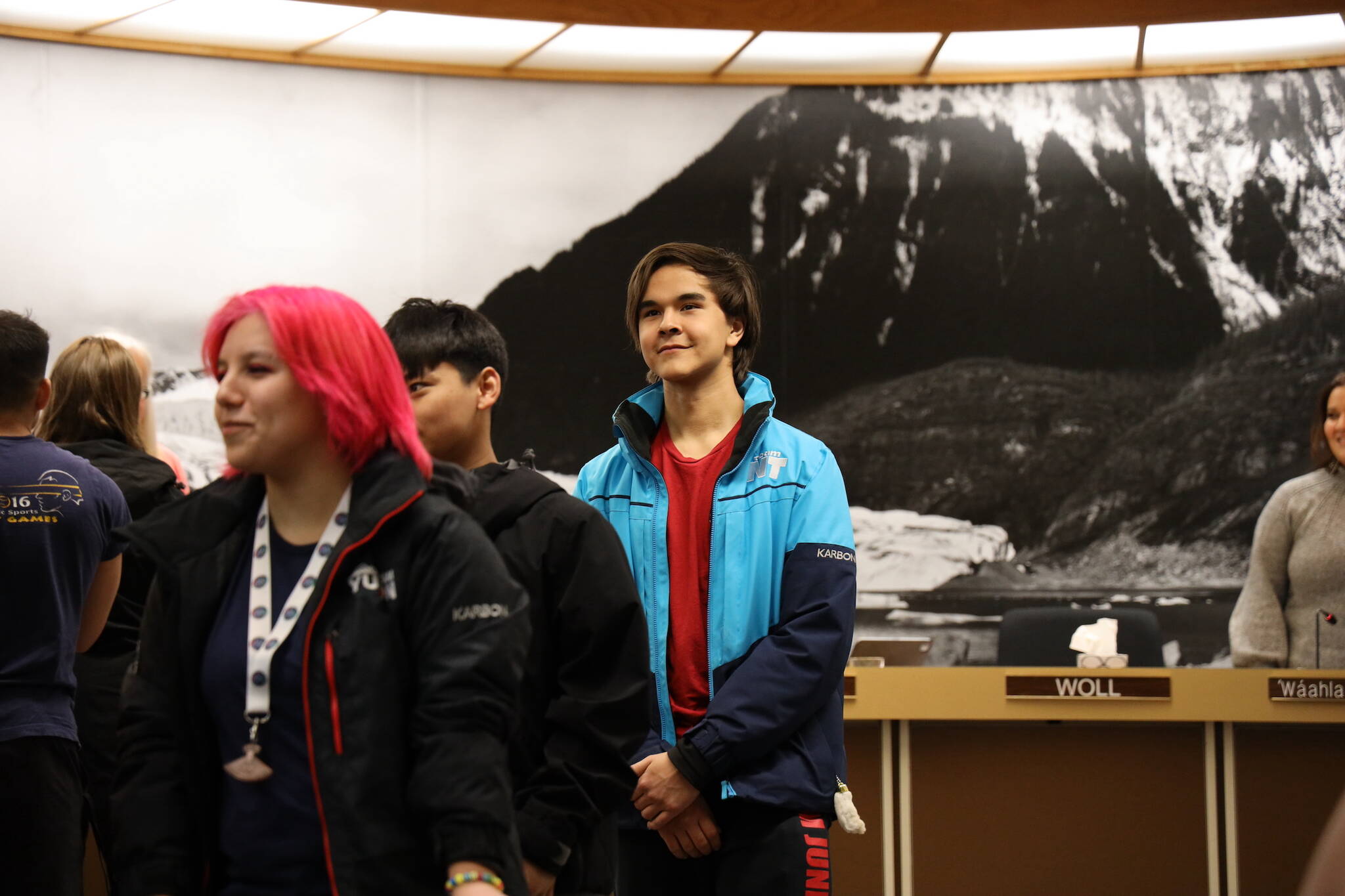 Nathan Blake waits to shake hands with City and Borough of Juneau administration and Assembly members Monday night after being honored alongside other athletes for their representation of Juneau for Team Alaska at the 2023 Arctic Winter Games in February. (Clarise Larson / Juneau Empire)