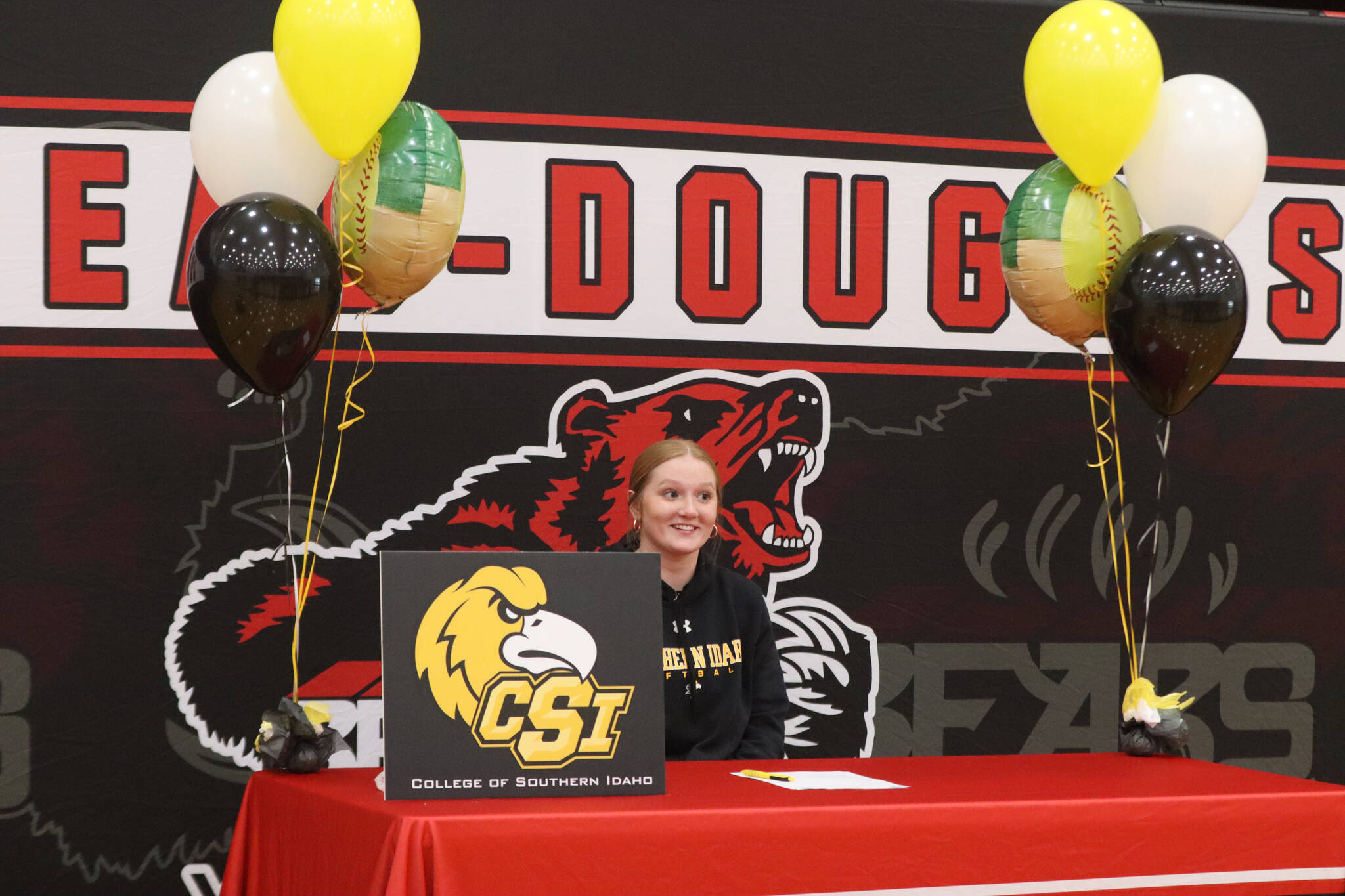 JDHS senior Mariah Schauwecker sits before friends and family on Wednesday at the JDHS gymnasium to sign a letter of intent to play softball with Southern Idaho. (Jonson Kuhn / Juneau Empire)