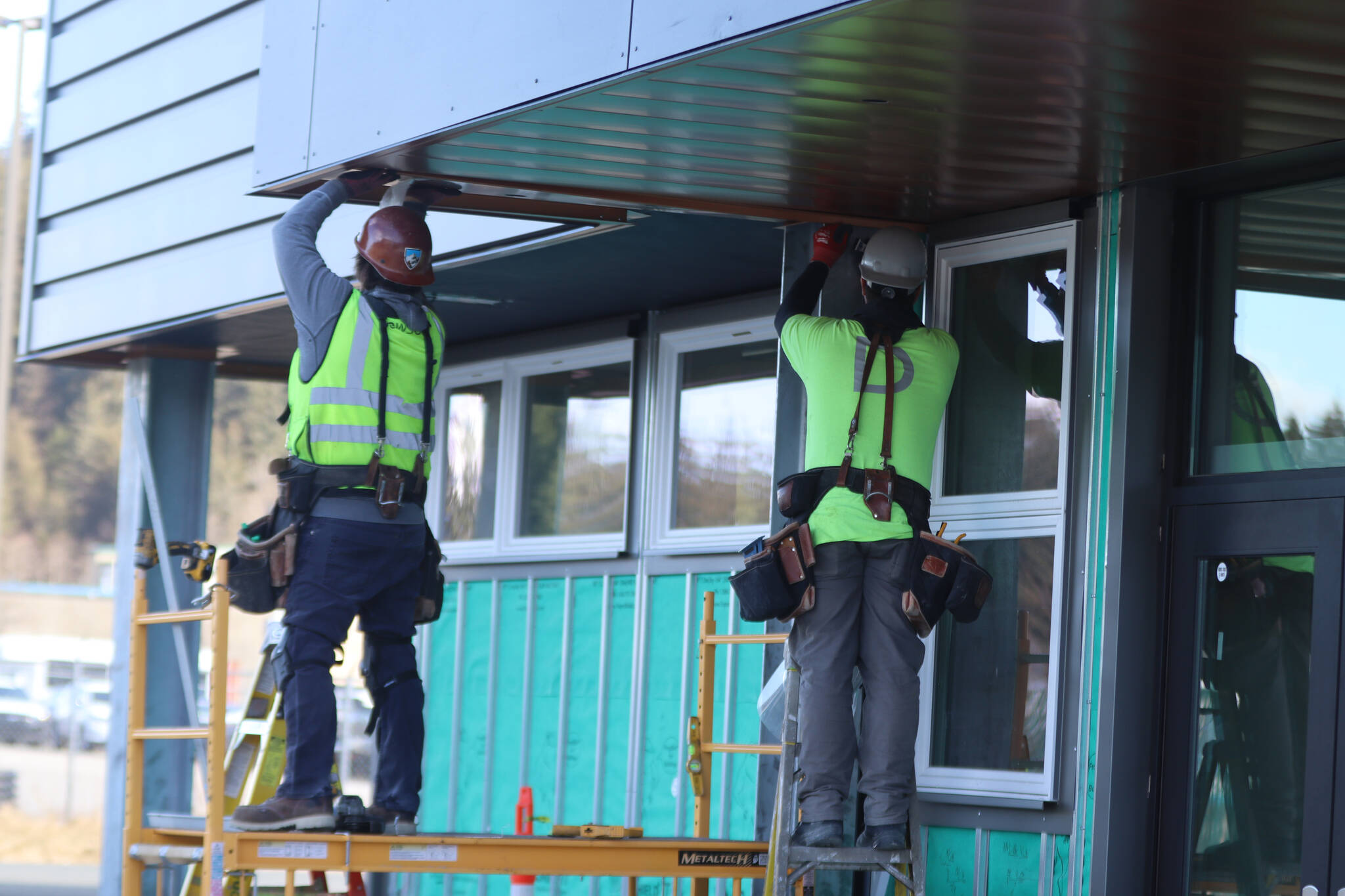 Construction crews perform remaining exterior work left on the Teal Street Center, which is tentatively scheduled to be wrapped up by the end of the summer. While minor exterior construction remains, offices are open to the public to provide services. (Jonson Kuhn / Juneau Empire)