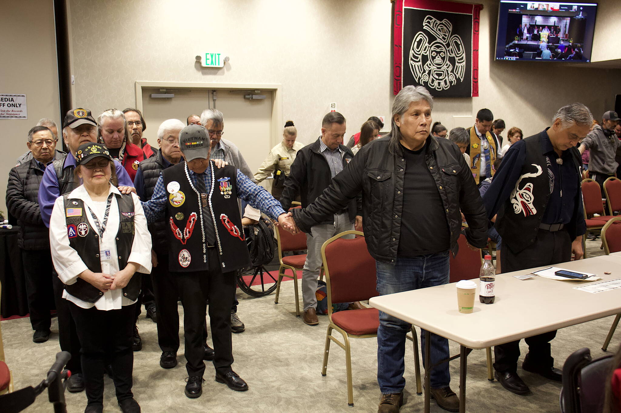 Southeast Alaska Native Veterans join hands in prayer for three employees of the Central Council of the Tlingit and Haida Indian Tribes of Alaska who were caught in an avalanche while driving from Whitehorse, Yukon Territory, to Skagway on during the 88th annual tribal assembly Friday. According to tribal officials the employees are safe, but little else was known Friday afternoon about the incident. (Mark Sabbatini / Juneau Empire)