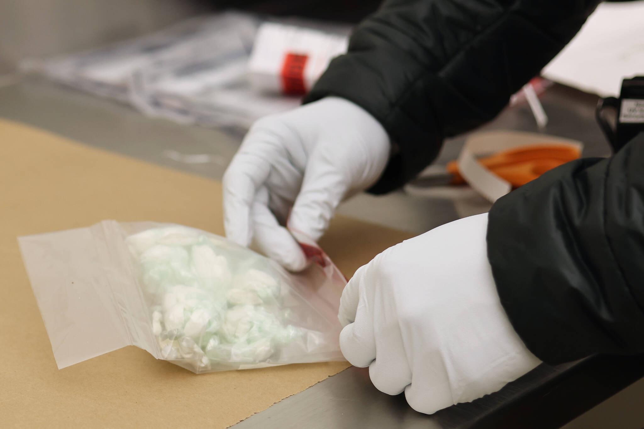 A tag is place on a evidence bag containing small baggies of drugs seized by the Juneau Police Department. (Ben Hohenstatt / Juneau Empire)