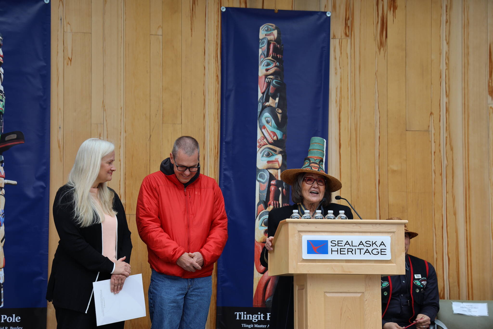 From left to right, City and Borough of Juneau Deputy Mayor Maria Gladziszewski, City Manager Rorie Watt and SHI President Rosita Worl laugh together during a speech at the dedication ceremony of the Kootéeyaa Deiyí, Totem Pole Trail, held Saturday in downtown Juneau at Heritage Plaza. (Clarise Larson / Juneau Empire)