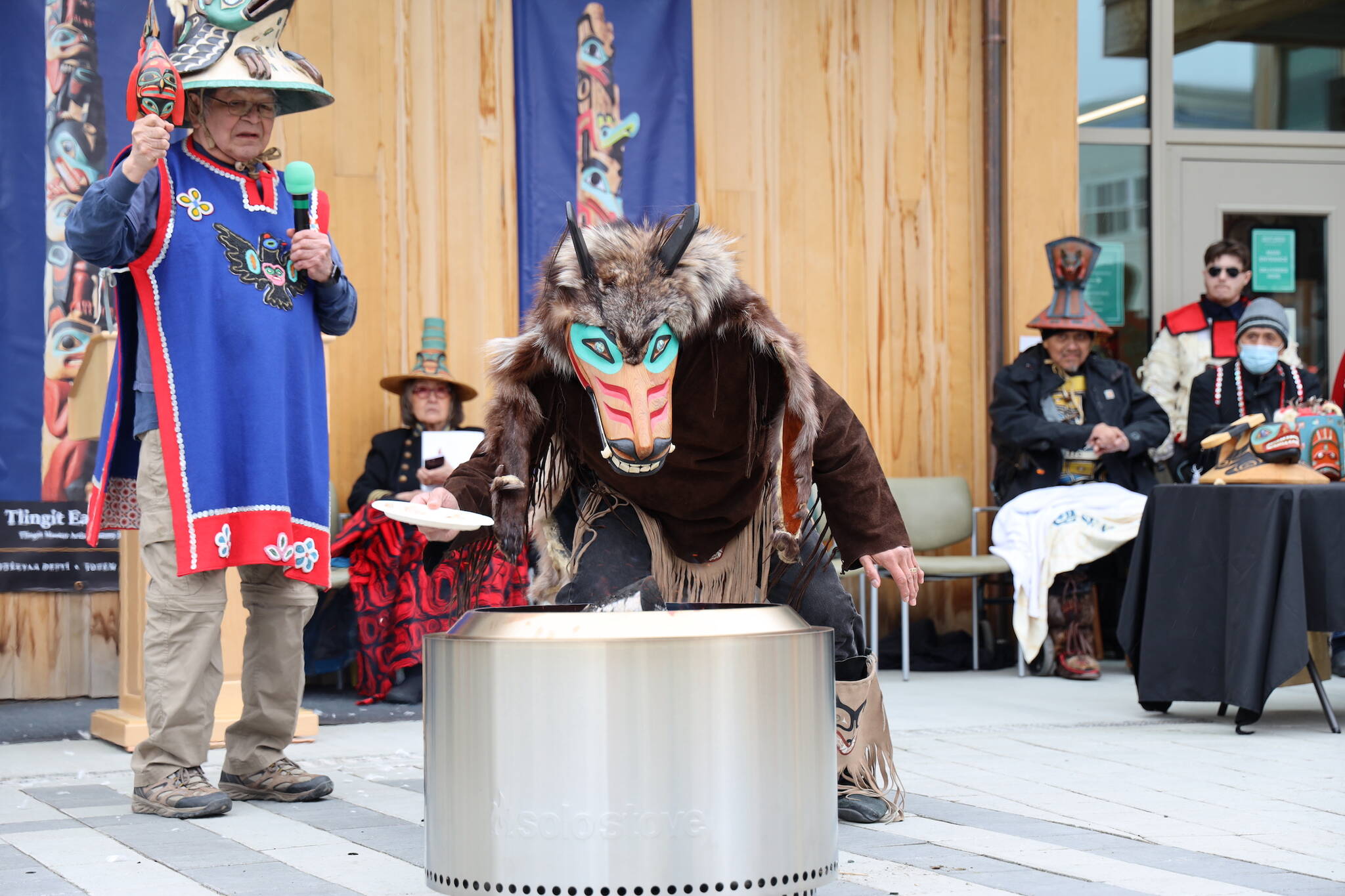 Kaax̱ḵaatuklag̱é Ken Grant sings a song as Ben Coronell performs a thanking and feeding the spirits of the trees ceremony during the dedication ceremony of the Kootéeyaa Deiyí, Totem Pole Trail, held Saturday in downtown Juneau at Heritage Plaza. (Clarise Larson / Juneau Empire)