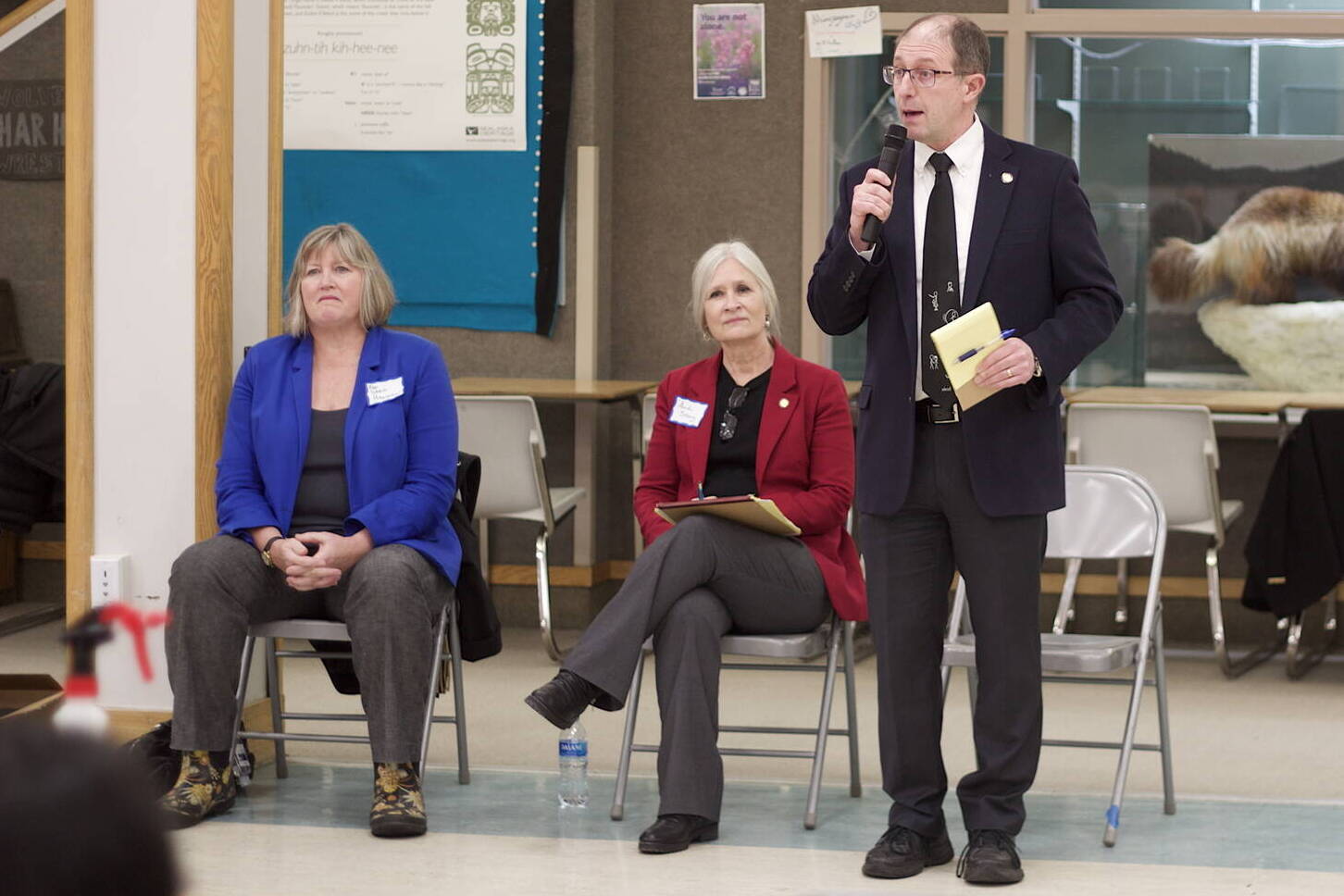 Mark Sabbatini / Juneau Empire file 
Juneau state Sen. Jesse Kiehl, standing, addresses a town hall audience Jan. 11 at Dzantik’i Heeni Middle School as Juneau state Reps. Sarah Hannan, far left, and Andi Story wait their turn to discuss their priorities during the current legislative session.