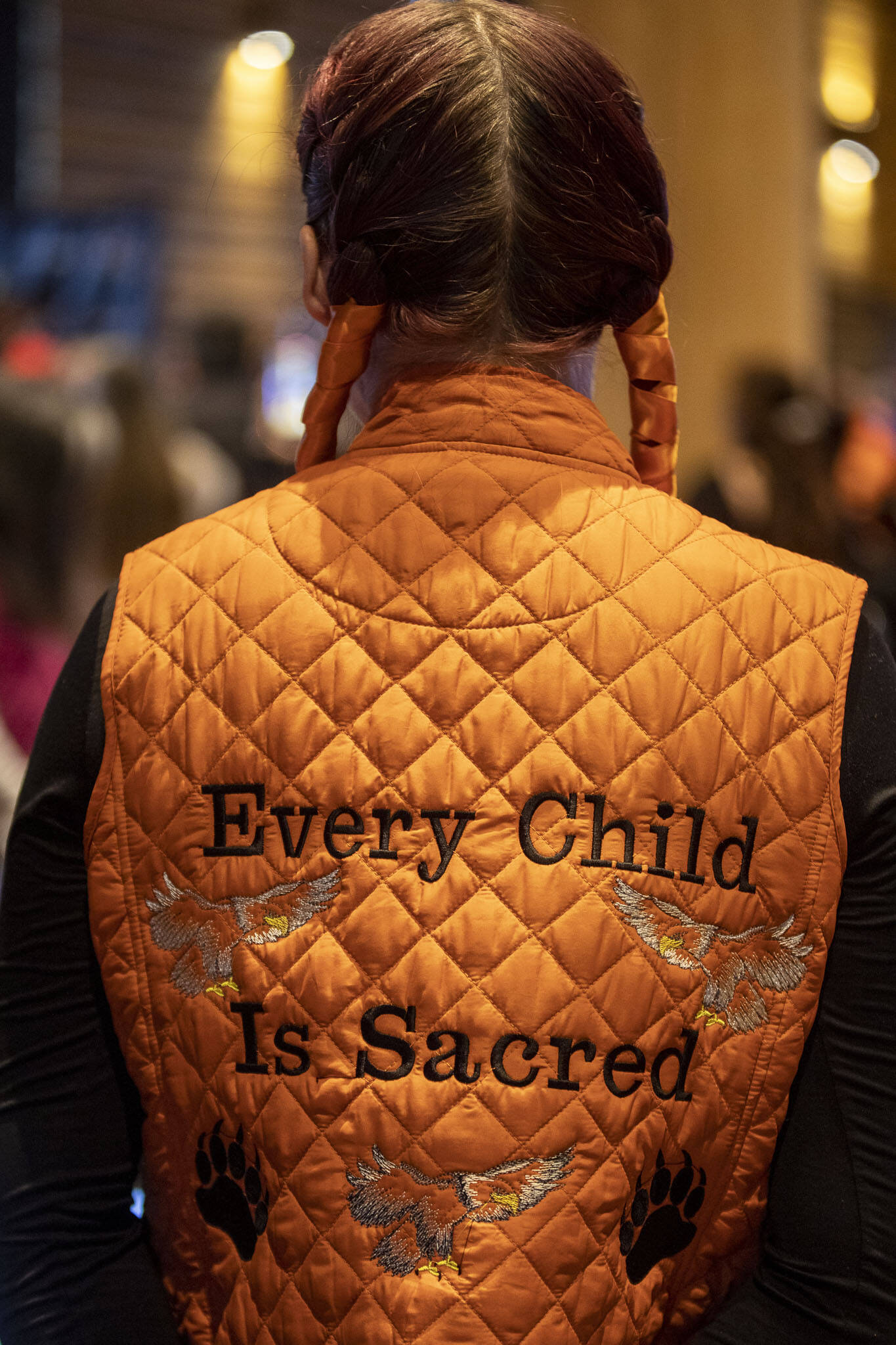 A person wears a vest that says “Every Child Is Sacred” during a Road to Healing event at the Tulalip Gathering Hall in Marysville, Washington on Sunday, April 23, 2023. The tour is lead by United States Secretary of the Interior Deb Haaland and Department of the Interior Assistant Secretary Bryan Newland. (Annie Barker / The Herald)