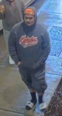 The Juneau Police Department is asking the community to assist in identifying a man who allegedly threw a large rock at a police patrol vehicle windshield at around 2:30 a.m. on April 16. This is a picture shared by police of the the man wearing an orange cap and gray hoody as seen in surveillance footage. (Juneau Police Department)