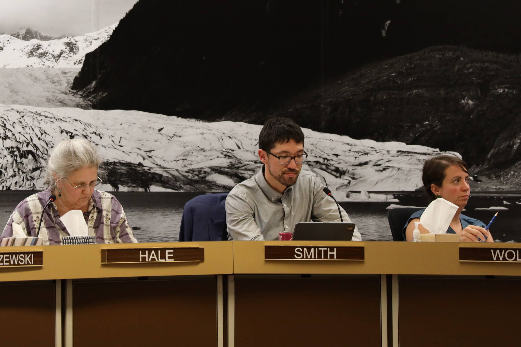 From left to right, City and Borough of Juneau Assembly members Michelle Bonnet Hale, Greg Smith and Christine Woll listen to discussion Wednesday night from other Assembly members about the community funding requests for the 2023 fiscal year budget. (Clarise Larson / Juneau Empire)