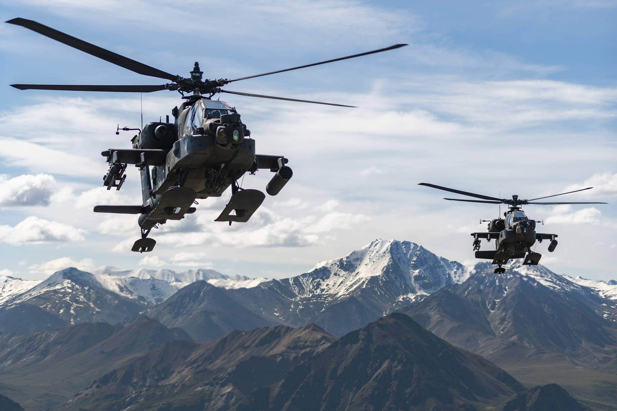 In this photo released by the U.S. Army, AH-64D Apache Longbow attack helicopters from the 1st Attack Battalion, 25th Aviation Regiment, fly over a mountain range near Fort Wainwright, Alaska, on June 3, 2019. The U.S. Army says two Army helicopters similar to the ones in this picture crashed Thursday, April 27, 2023, near Healy, Alaska, killing three soldiers and injuring a fourth. The helicopters were returning from a training flight to Fort Wainwright, based near Fairbanks. (Cameron Roxberry / U.S. Army)