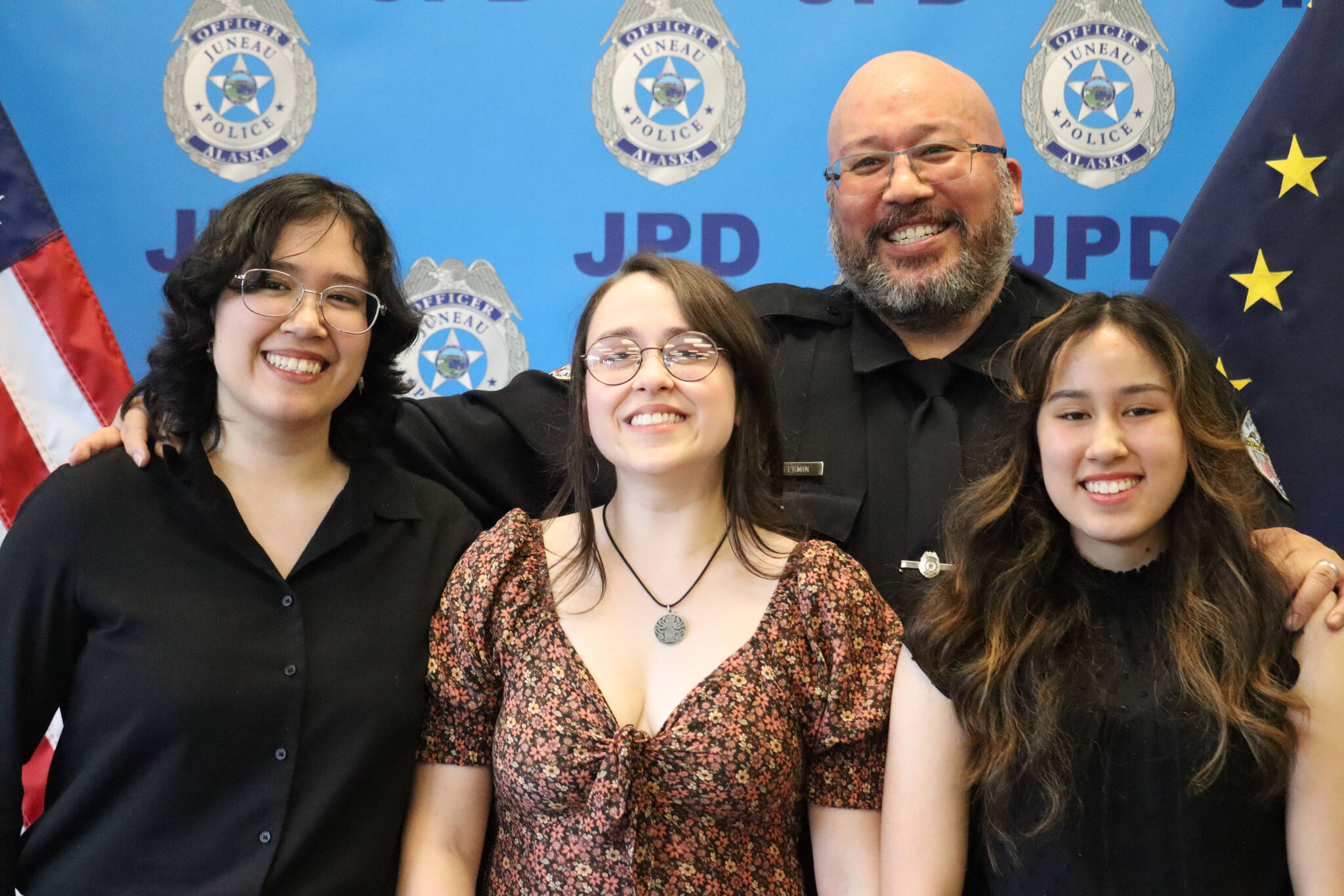 JPD Officer Kevin Fermin poses with daughter Sami Martinez and family on Friday at the closing of Fermin’s retirement ceremony after 25 years of serving the Juneau community. (Jonson Kuhn / Juneau Empire)