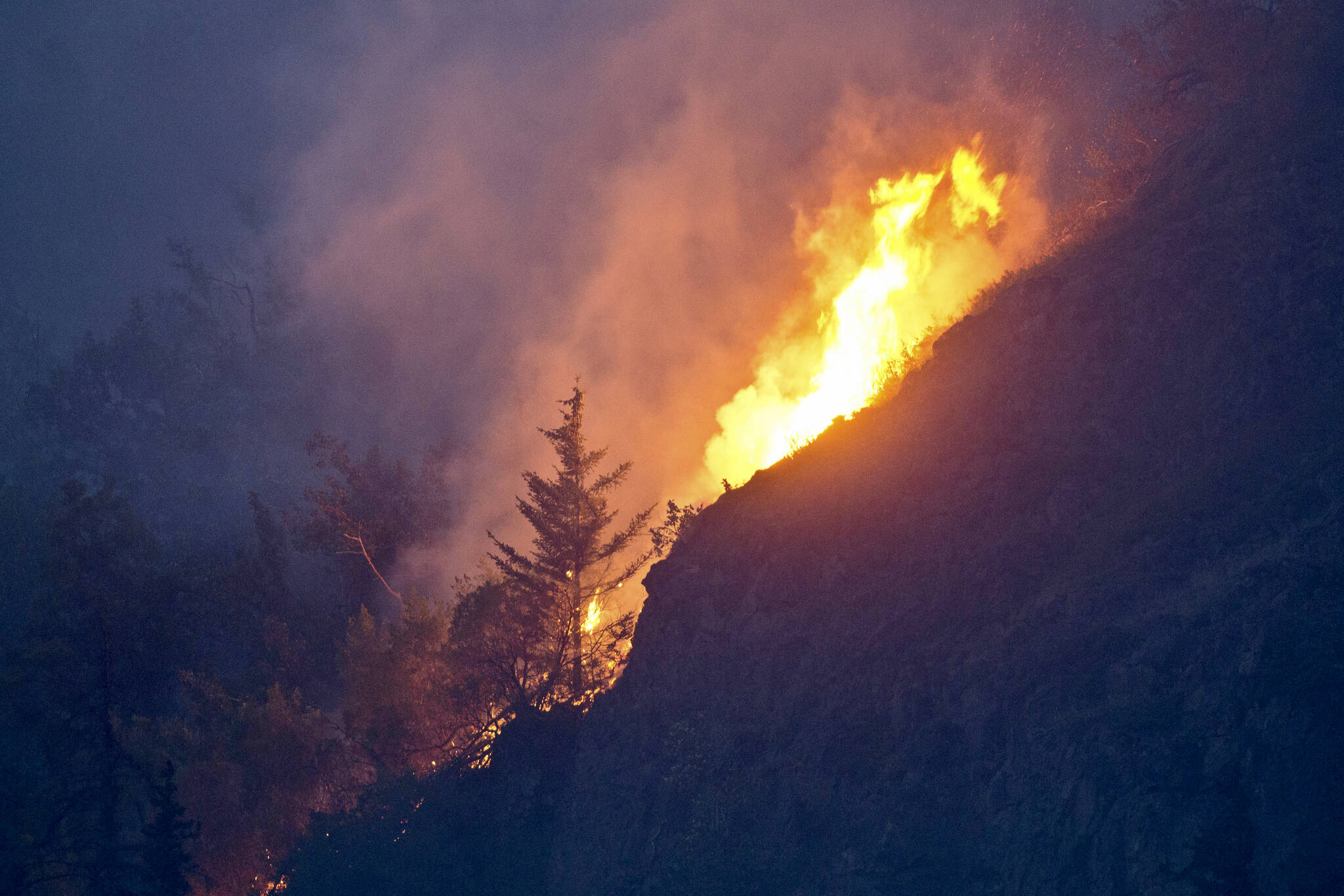 Flames are visible from the Beluga Point parking area near Anchorage on July 19, 2016, as a wildfire near McHugh Creek burns. A recent series of wildfires near Anchorage and the hottest day on record have sparked fears that a warming climate could soon mean serious, untenable blazes in urban areas — just like in the rest of the drought-plagued American West. (Marc Lester / Anchorage Daily News)