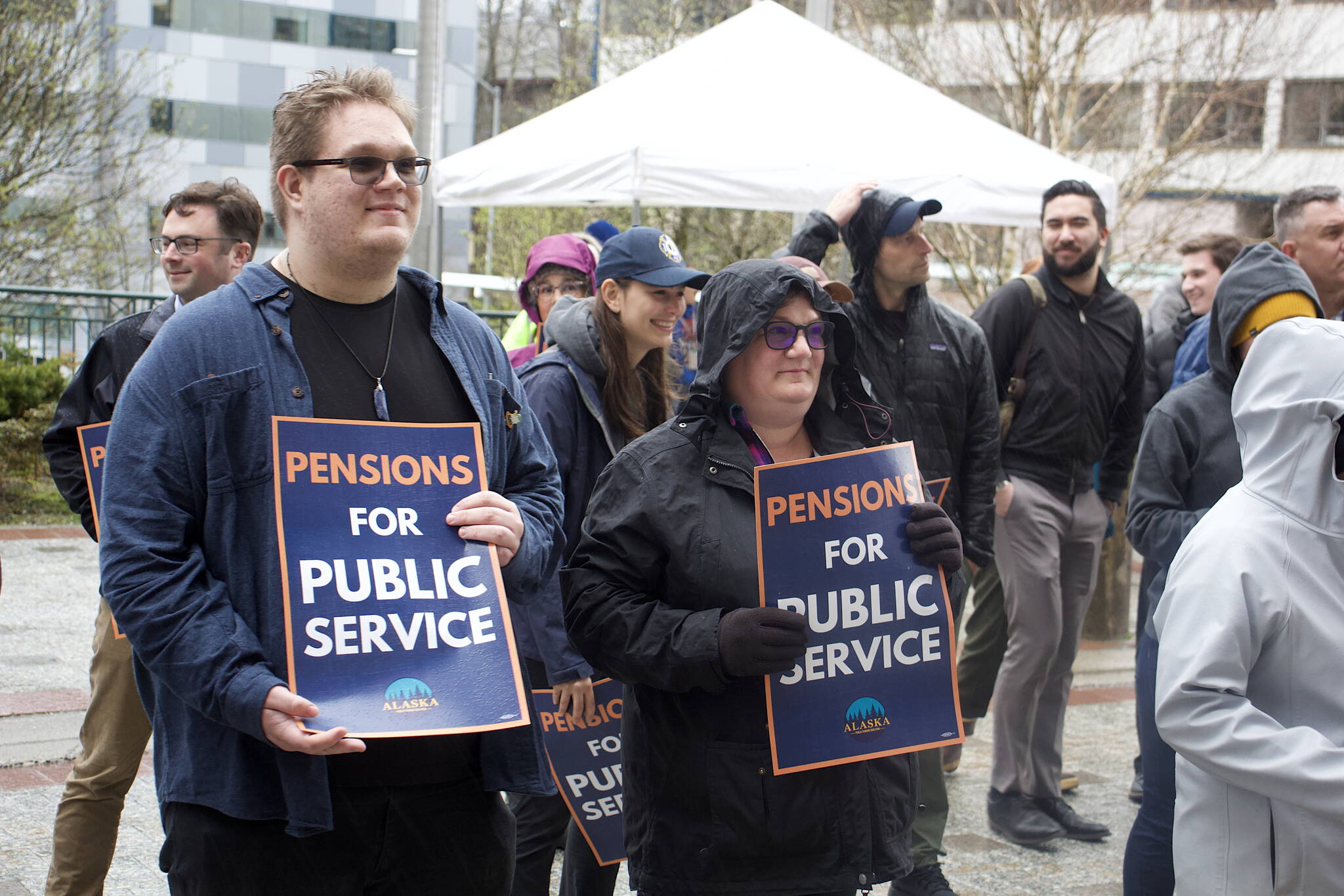 Supporters of a bill returning pensions for state employees to a fixed-benefits system used until 2006 instead of the 401K-style system that followed gather in the rain in front of the Alaska State Capitol during a rally Tuesday evening. (Mark Sabbatini / Juneau Empire)