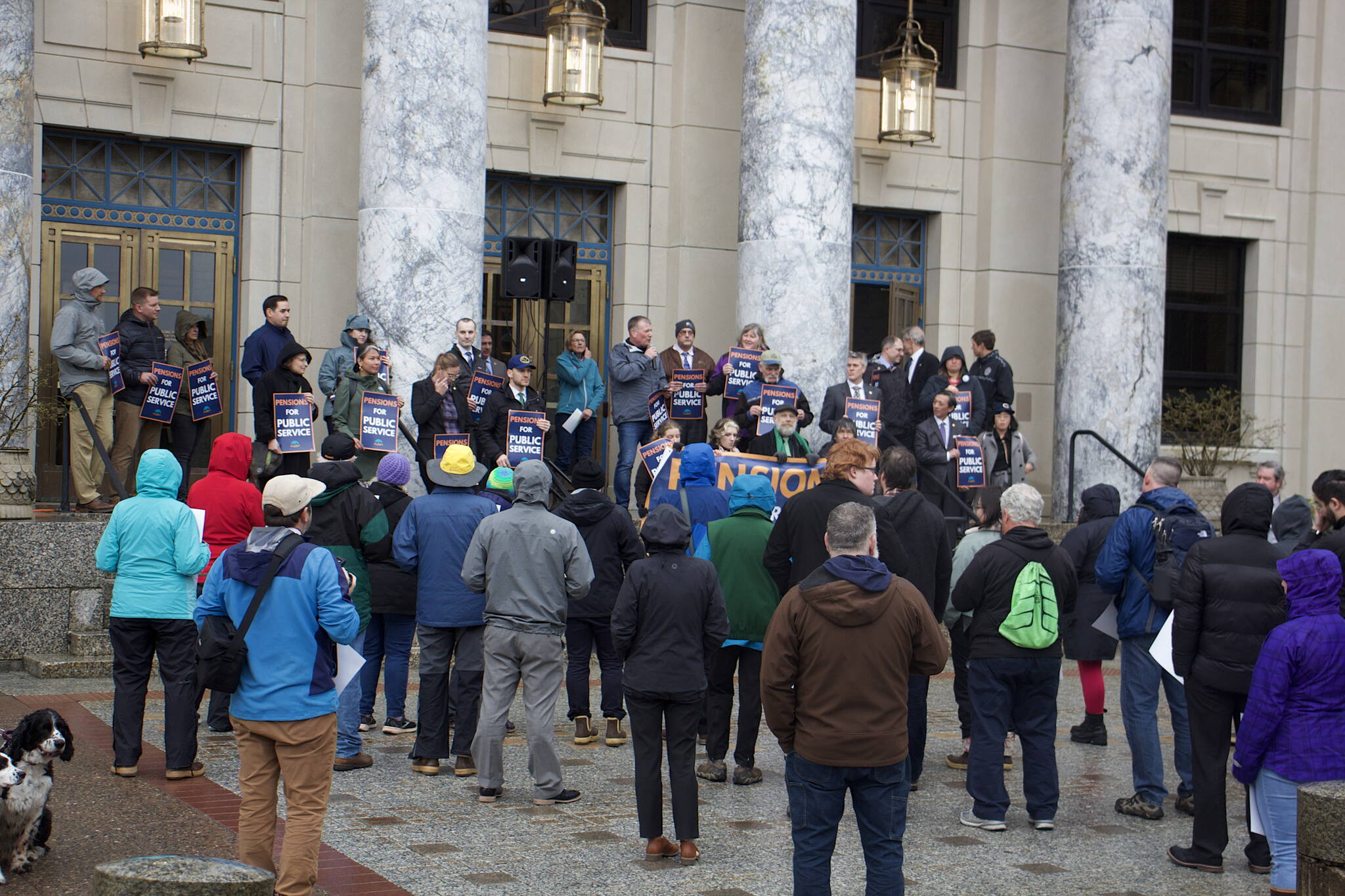 About 70 people, including 20 state lawmakers, gather in front of the Alaska State Capitol for a rally supporting a boost to public employee pensions on Tuesday evening. (Mark Sabbatini / Juneau Empire)