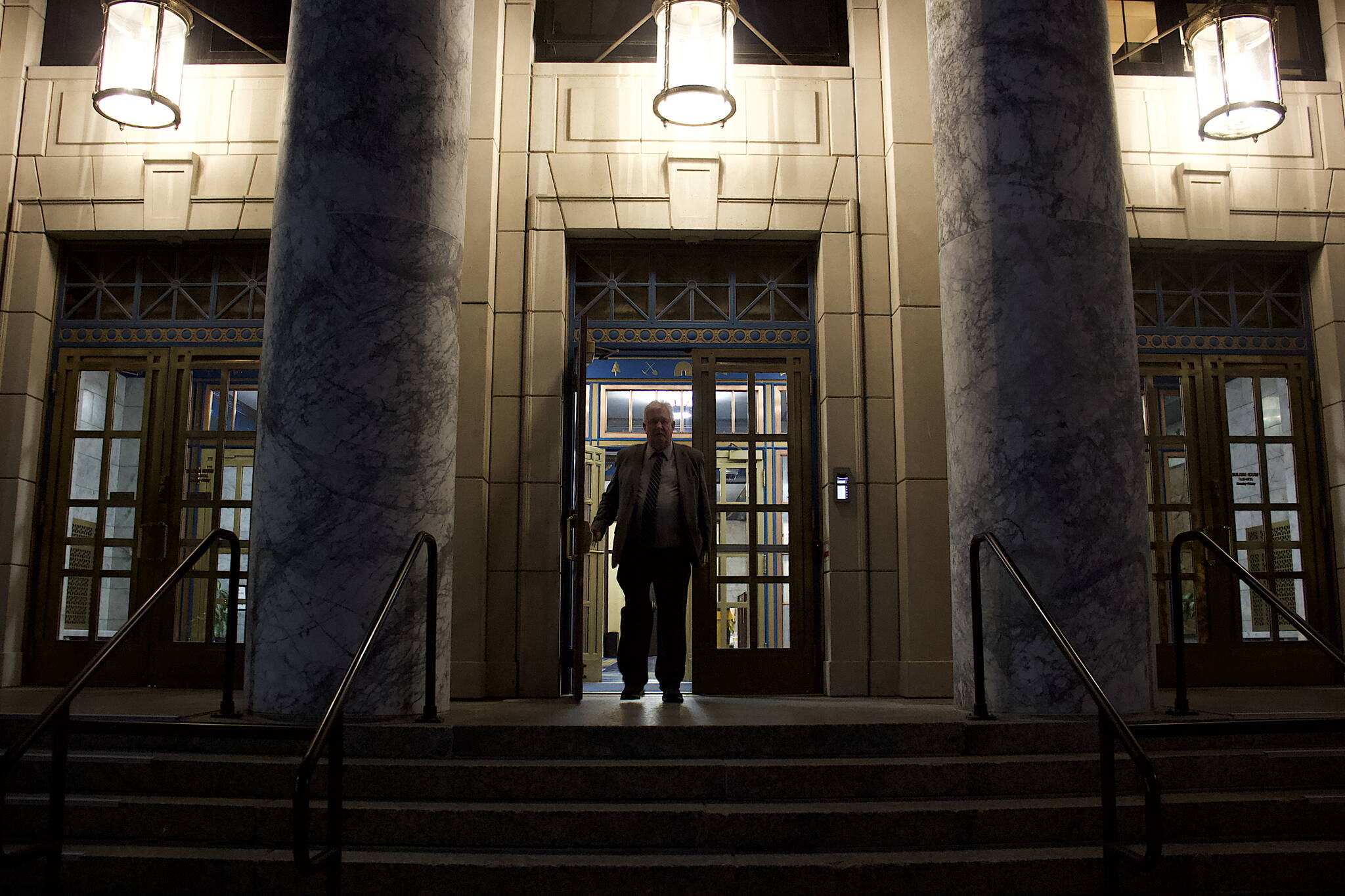 A legislative staff member leaves the Alaska State Capitol late Monday night after the House Finance Committee took a series of actions on bill aimed at resolving differences with the Senate in order to adjourn the regulation session by its Wednesday deadline. (Mark Sabbatini / Juneau Empire)