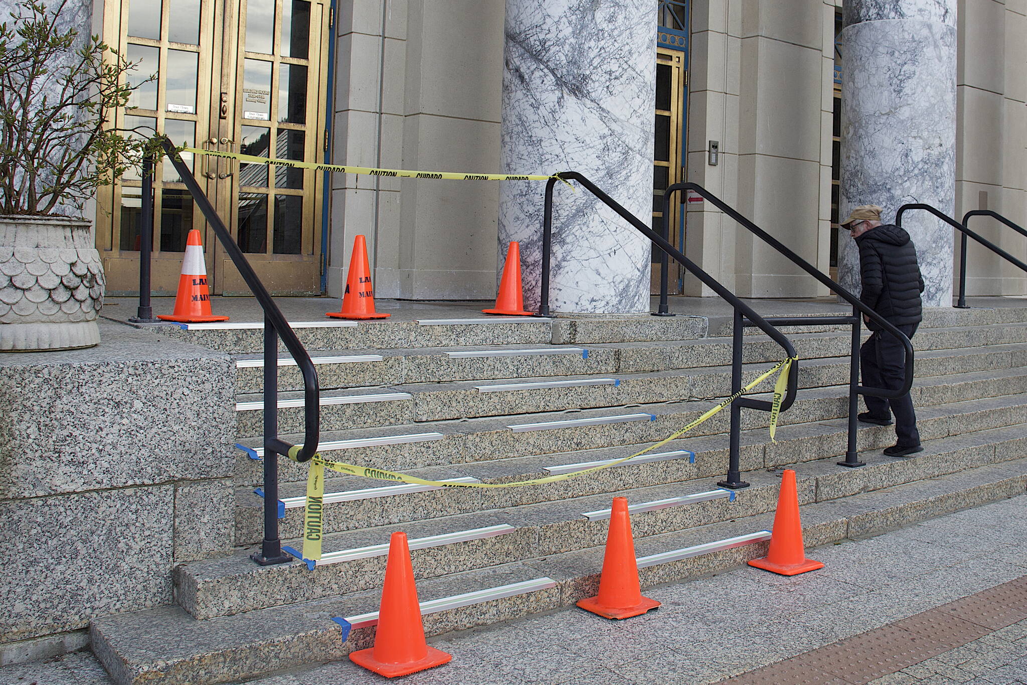 A person entering the Alaska State Capitol on Wednesday morning looks at reflective anti-slip strips being installed on the stairs. The entrance stairs of the 82-year-old building are slippery when wet or icy, and the initial weeks of the legislature session occur when Juneau is experiencing long hours of darkness. (Mark Sabbatini / Juneau Empire)