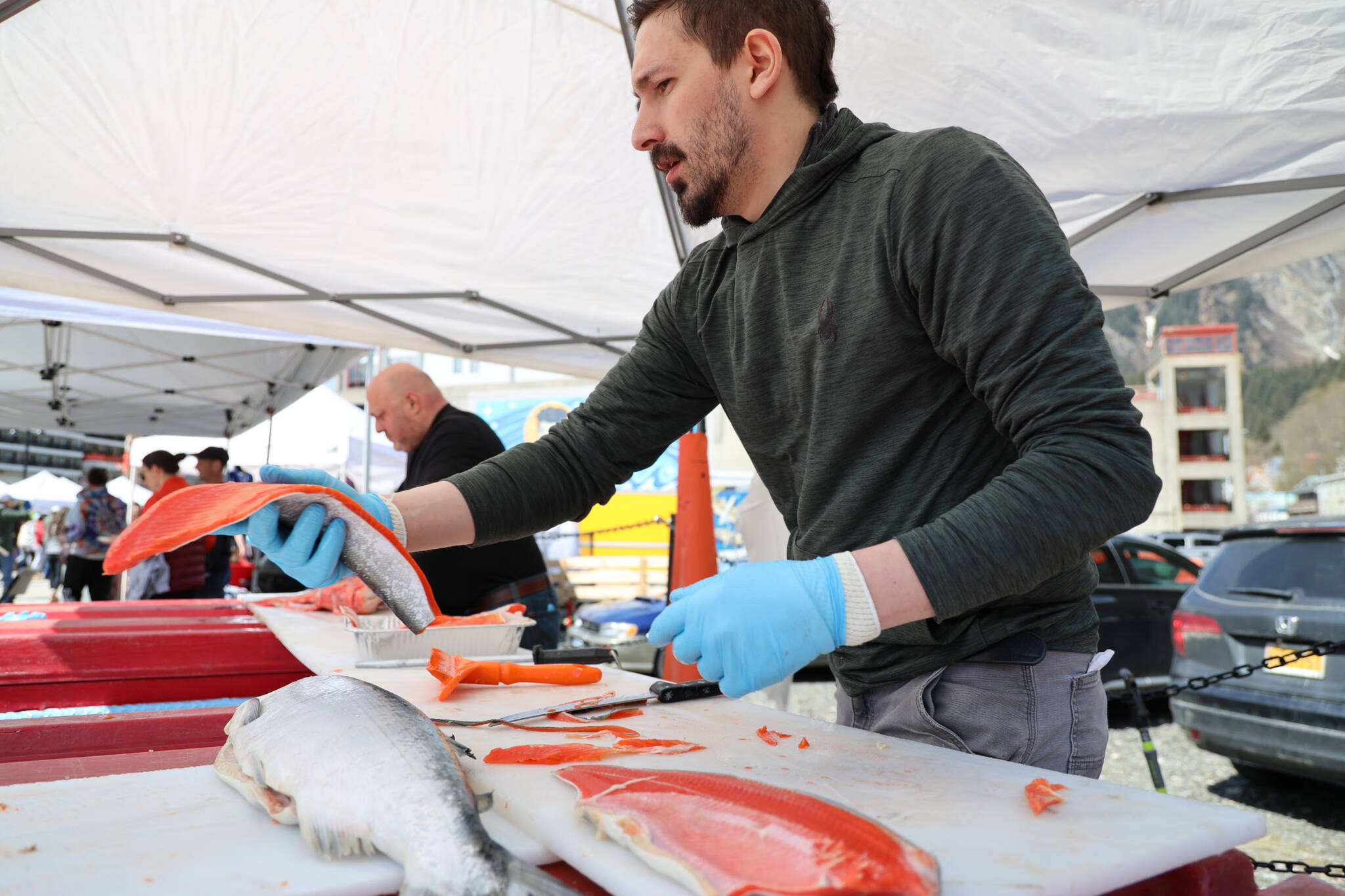 Jared Jerabek with Alaska Glacier Seafood fillets sockeye salmon to be cooked and handed out for free by Taku Smokeries during 2023 Juneau Maritime Festival Saturday afternoon at the Elizabeth Peratrovich Plaza. (Clarise Larson / Juneau Empire)