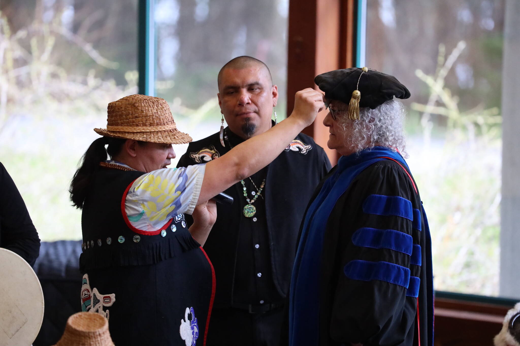 X’unei Lance Twitchell, professor of Alaska Native languages at UAS, performs a naming ceremony for retiring University of Alaska Southeast Chancellor Karen Karey during the Annual Native Graduation Celebration at the Egan Library Saturday morning before commencement. Her name, Heidé Shuwataani, means “the one who opens doors.” (Clarise Larson / Juneau Empire)