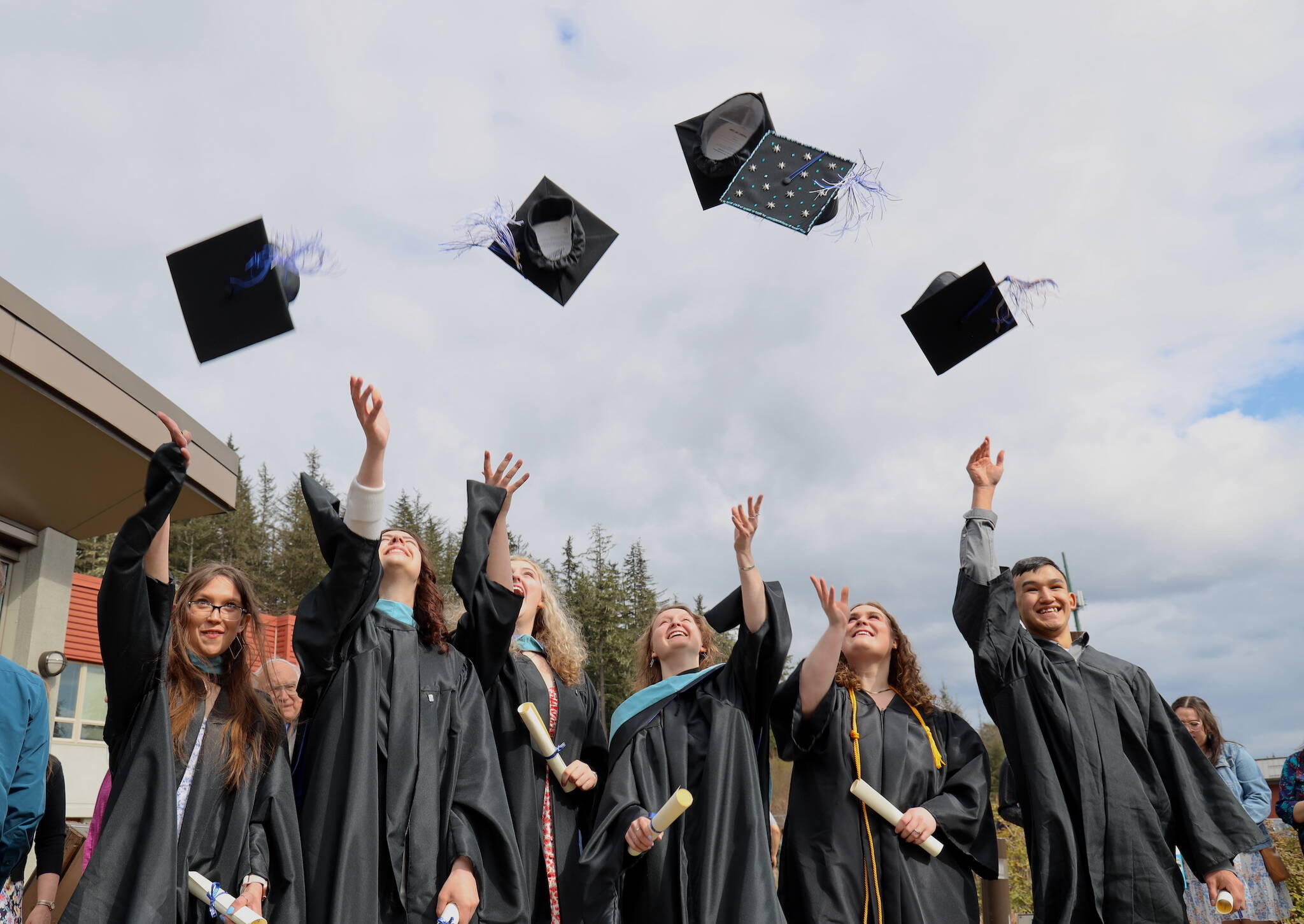 Graduates Emily Hatley, Lara Millette, Autumn Levy, Rosaline Westfall, Rylee Johnson and Jarvis Evans throw their caps in the air after the commencement ceremony held Sunday afternoon at the University of Alaska Southeast. (Clarise Larson / Juneau Empire)