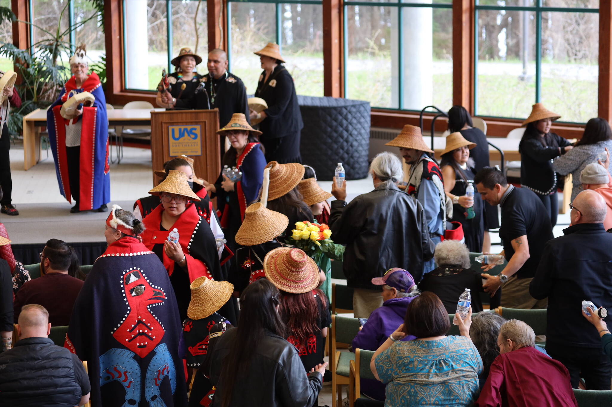 Faculty and dancers hand out gifts of water and body butter to graduates and family members during the Annual Native Graduation Celebration at the Egan Library Saturday morning before commencement. (Clarise Larson / Juneau Empire)