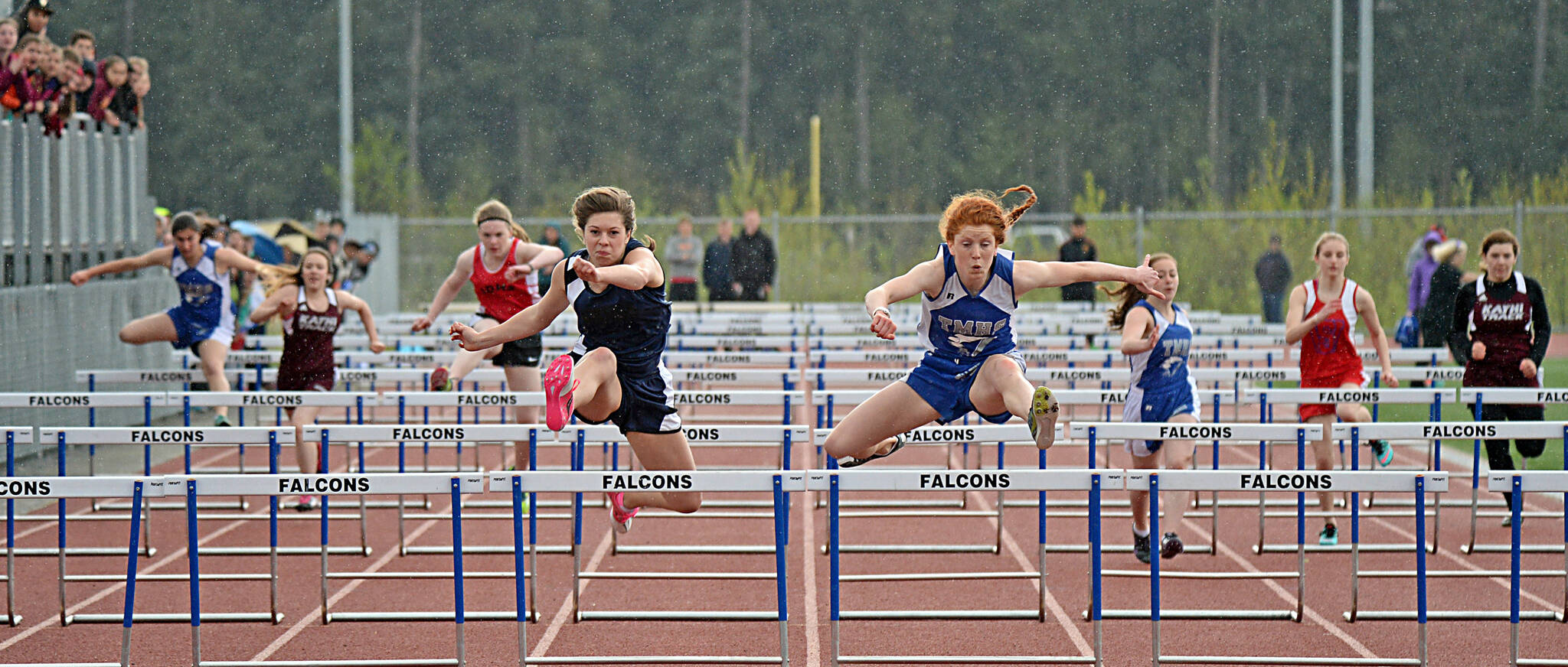 Petersburg High School sophomore Izabelle Ith, left, and Thunder Mountain junior Naomi Welling lead the field in the girls 100-meter hurdles finals at the 2015 Capital City Invitational. (Klas Stolpe / Juneau Empire)