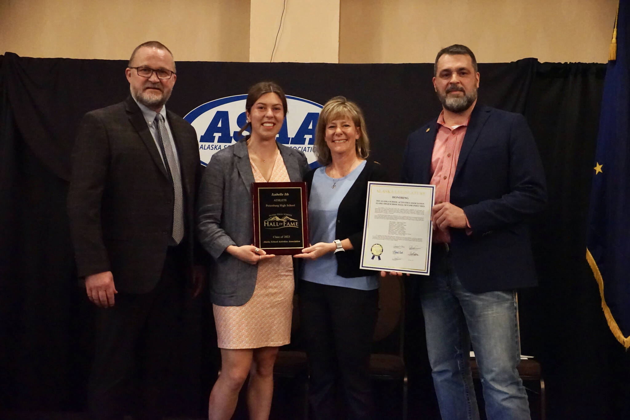 Izabelle Ith, second from left, poses with her Alaska High School Hall of Fame plaque. At left is ASAA Executive Director Billy Strickland. Second from right is Jo Ann Day, who nominated Ith for the honor. At right is Alaska state Rep. Mike Cronk who presented Ith with a legislative citation. (Brad Potter / ASAA)