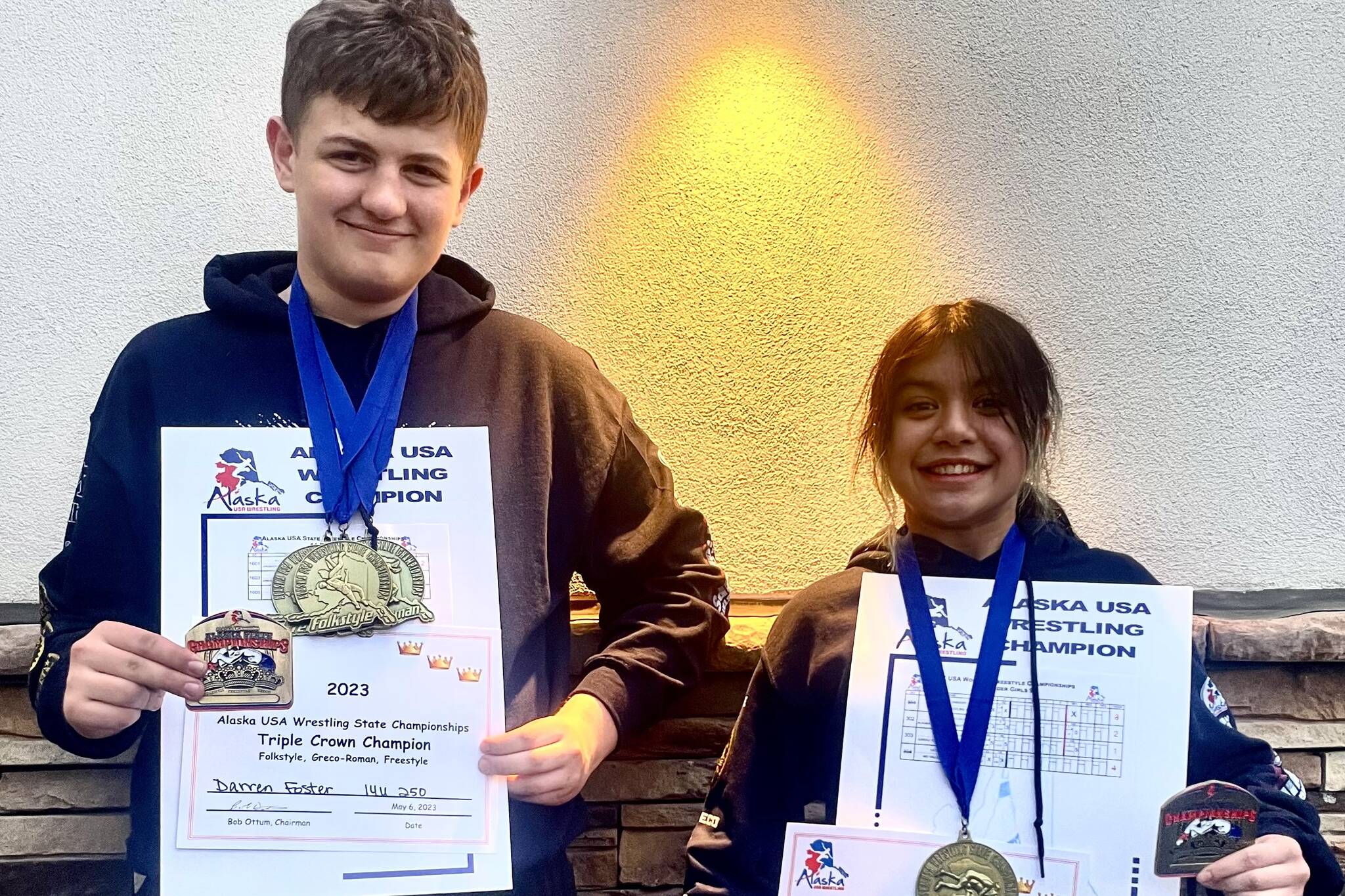Darren Foster and Nixie Schooler with some of their gold medals and their prestigious “Triple Crown” belt buckles at the USA Wrestling Alaska State Championships at the Menard Center in Wasilla from May 3-7. (Courtesy Photo / Jason Hass)