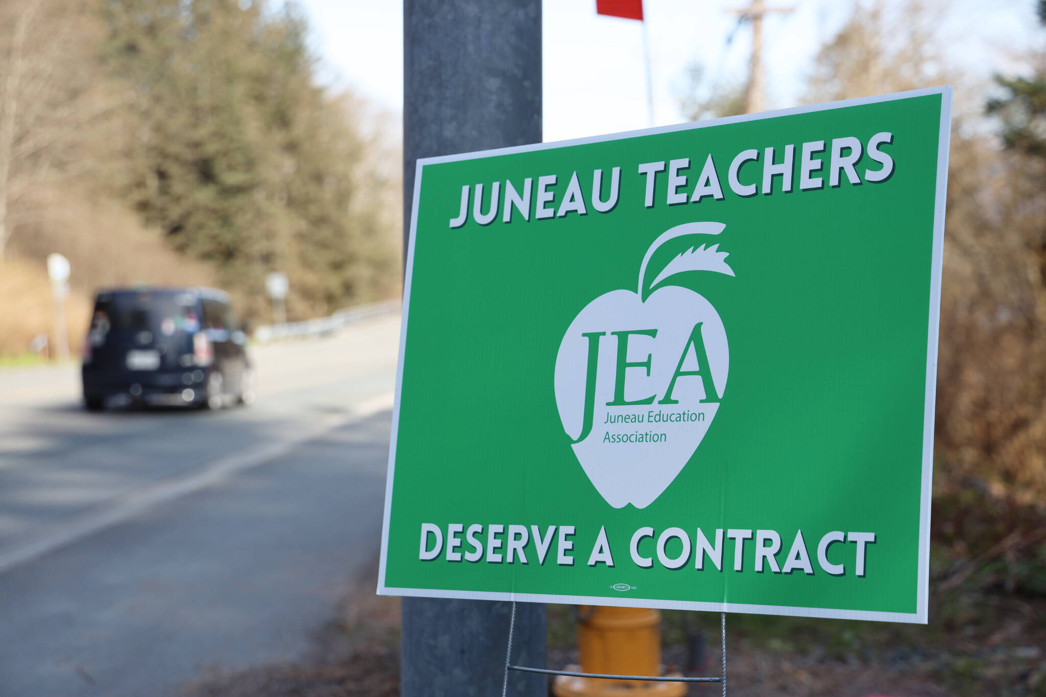 A car drives past a Juneau Education Association sign posted next to the North Douglas Highway in early May. On Friday the Juneau District Board of Education voted to accept a three-year contract agreement with Juneau Education Association, which OK’d the contract earlier in the week. (Clarise Larson / Juneau Empire)