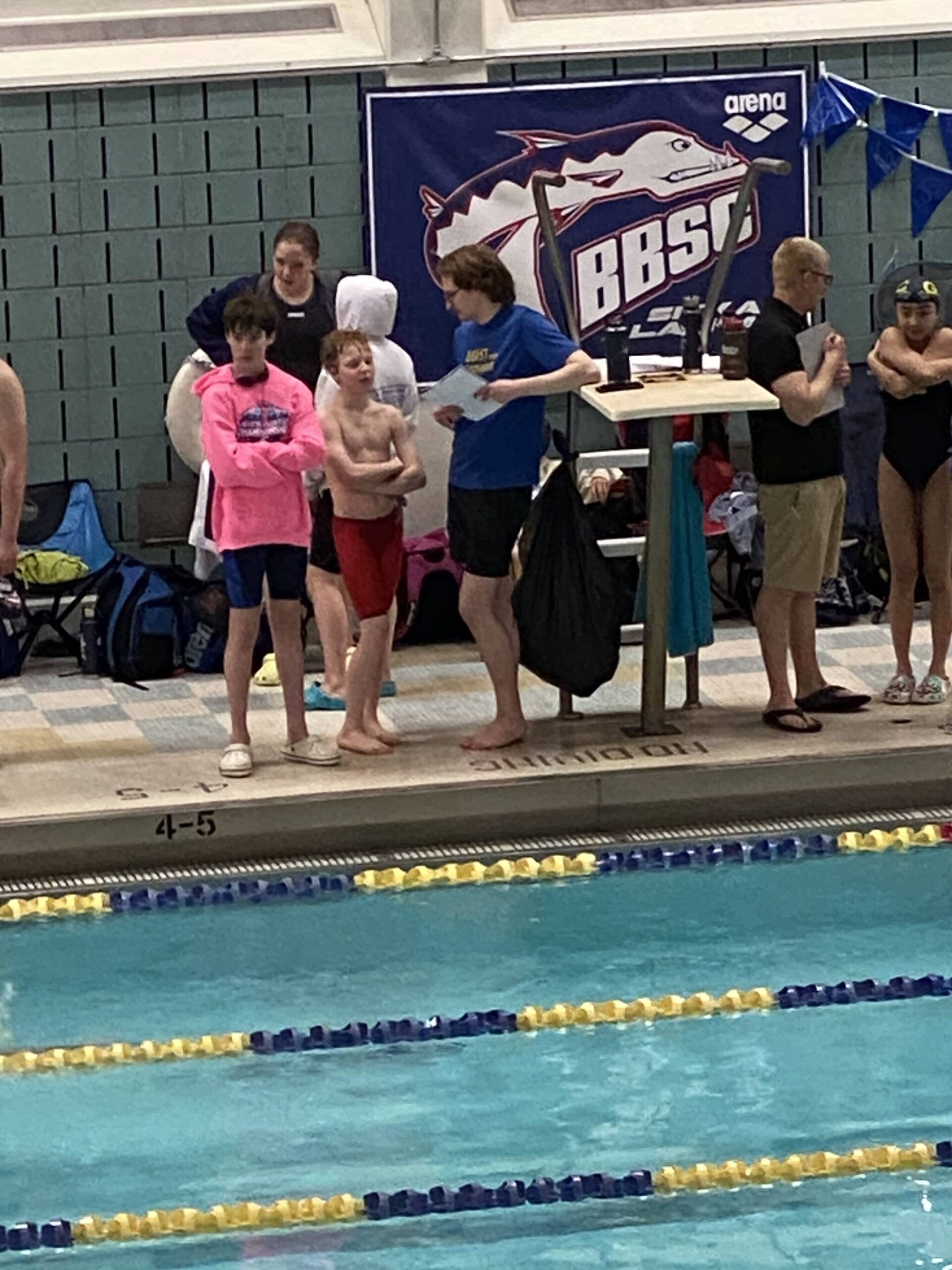 Andrew Sanders and Liam Kiessling speaking to Glacier Swim Club coach Josiah Loseby after a race at this year’s Alaska Swimming State Championship in Anchorage. (Courtesy Photo / Savona Kiessling)