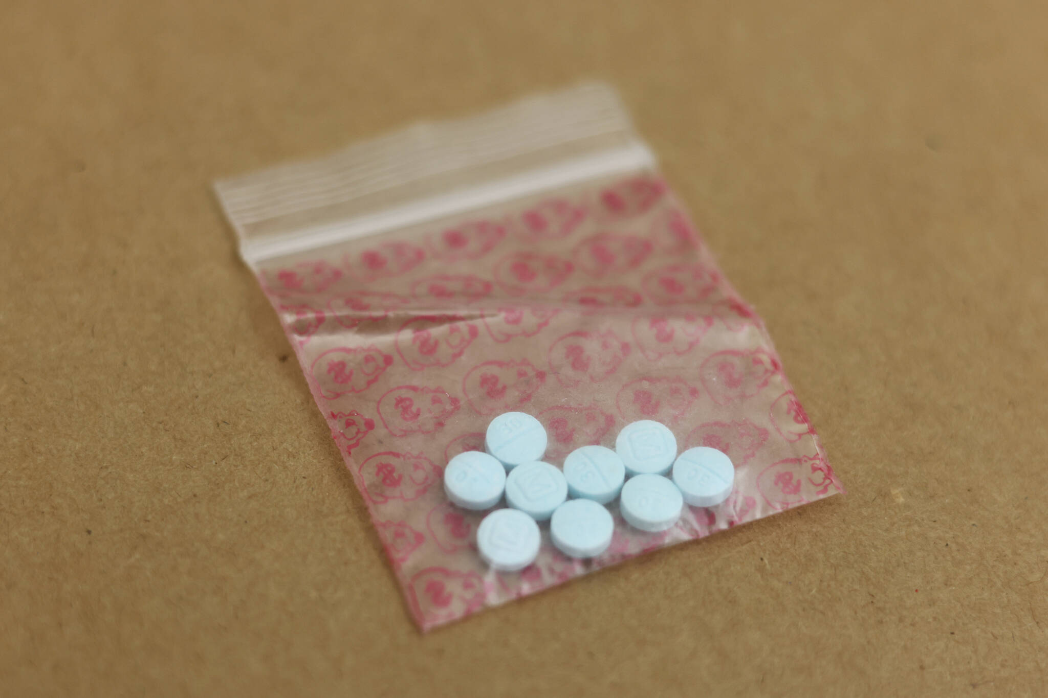 An evidence bag holds pills containing fentanyl at the Juneau Police Station. Curbing sales of fentanyl, a powerful synthetic opioid, via harsher penalties is a main focus of a bill that was heavily debated in the state House of Representatives this week. (Ben Hohenstatt / Juneau Empire File)