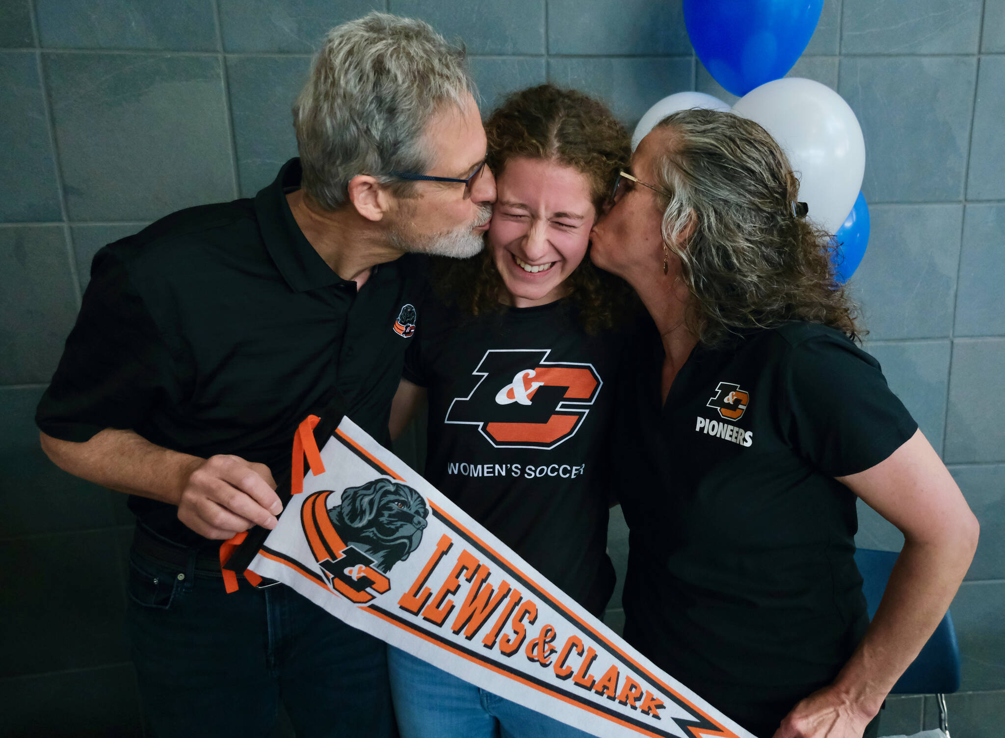 Mackenzie Olver is kissed by parents Barry and Stacy after signing a national letter of intent on Thursday in the Thunder Mountain commons, to play soccer and study at Lewis & Clark College in Portland, Oregon. (Klas Stolpe / Juneau Empire)