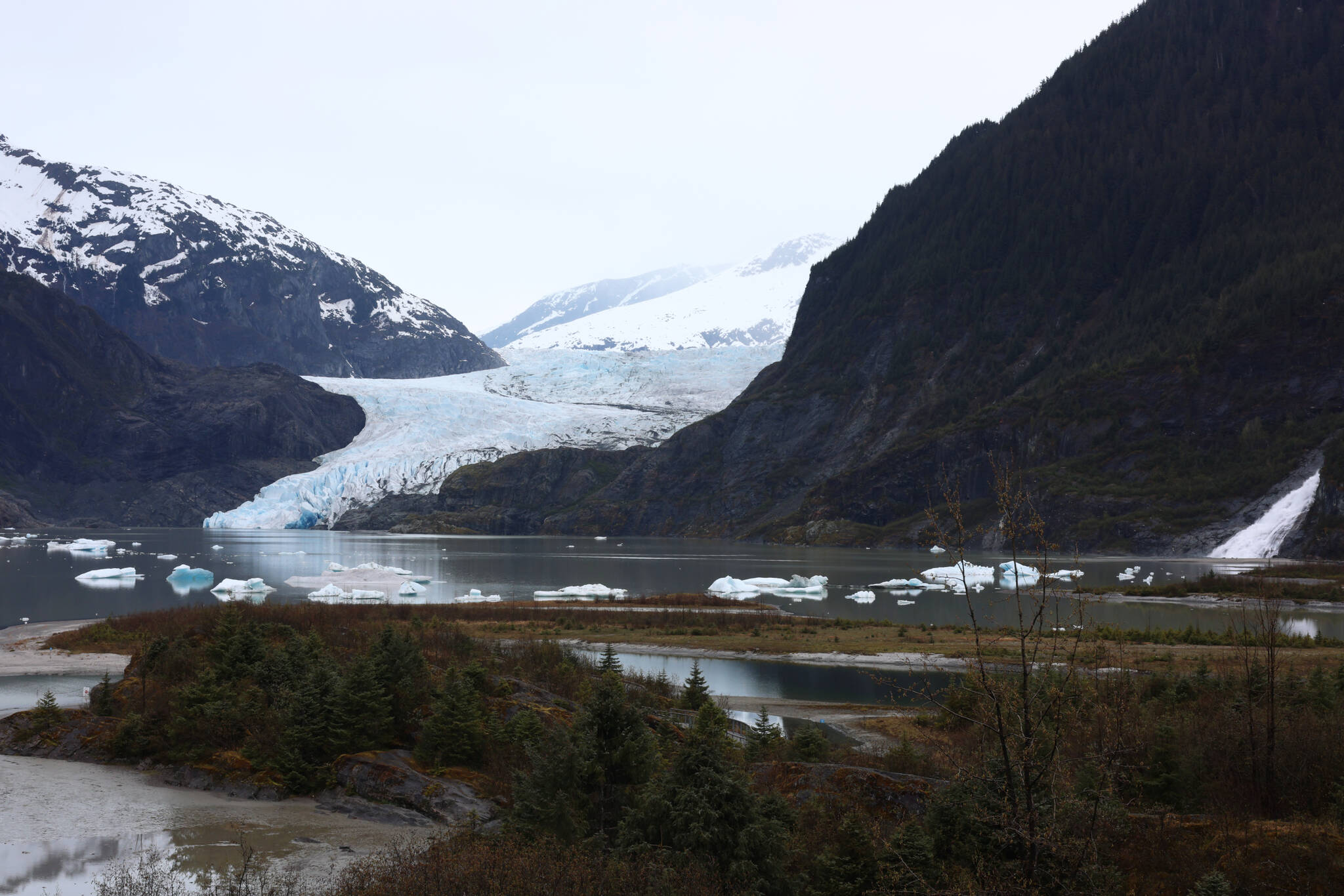 The Mendenhall Glacier, Photo Point and Nugget Falls are seen under cloudy skies Friday morning. The trails and recreation area around these heavily visited destinations are poised to change following the release of a final environmental impact statement. The U.S. Forest Service’s preferred alternative would nearly double the recreation area’s capacity in anticipation of demand over the next 30 years. (Ben Hohenstatt / Juneau Empire)