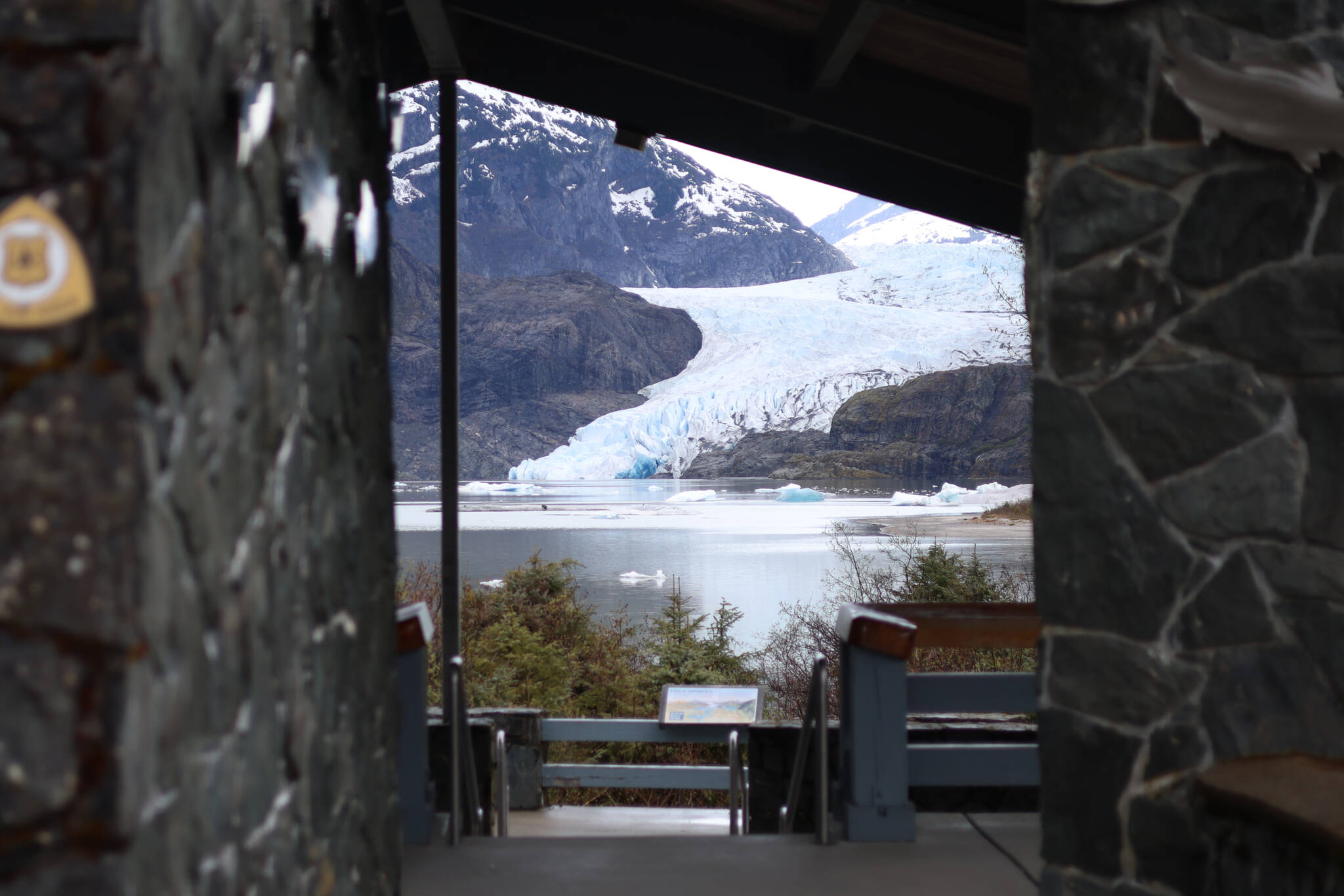 The Mendenhall Glacier is seen through the entrance of a pavilion near the Mendenhall Glacier Visitor Center on Friday. The area surrounding the visitor center will see significant changes under a plan to overhaul the Mendenhall Glacier Recreation Area. (Ben Hohenstatt / Juneau Empire)