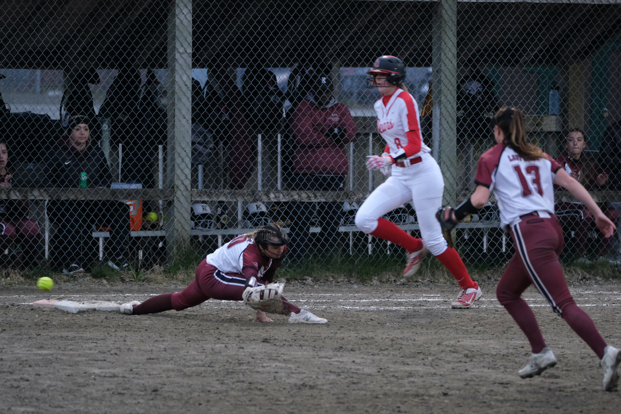 Juneau-Douglas High School: Yadaa.at Kalé junior Mila Hargrave (8) is safe at first as Ketchikan junior Rylie Welk misses the ball during the Crimson Bears and Lady Kings tie on Thursday at Melvin Park. (Klas Stolpe / Juneau Empire)