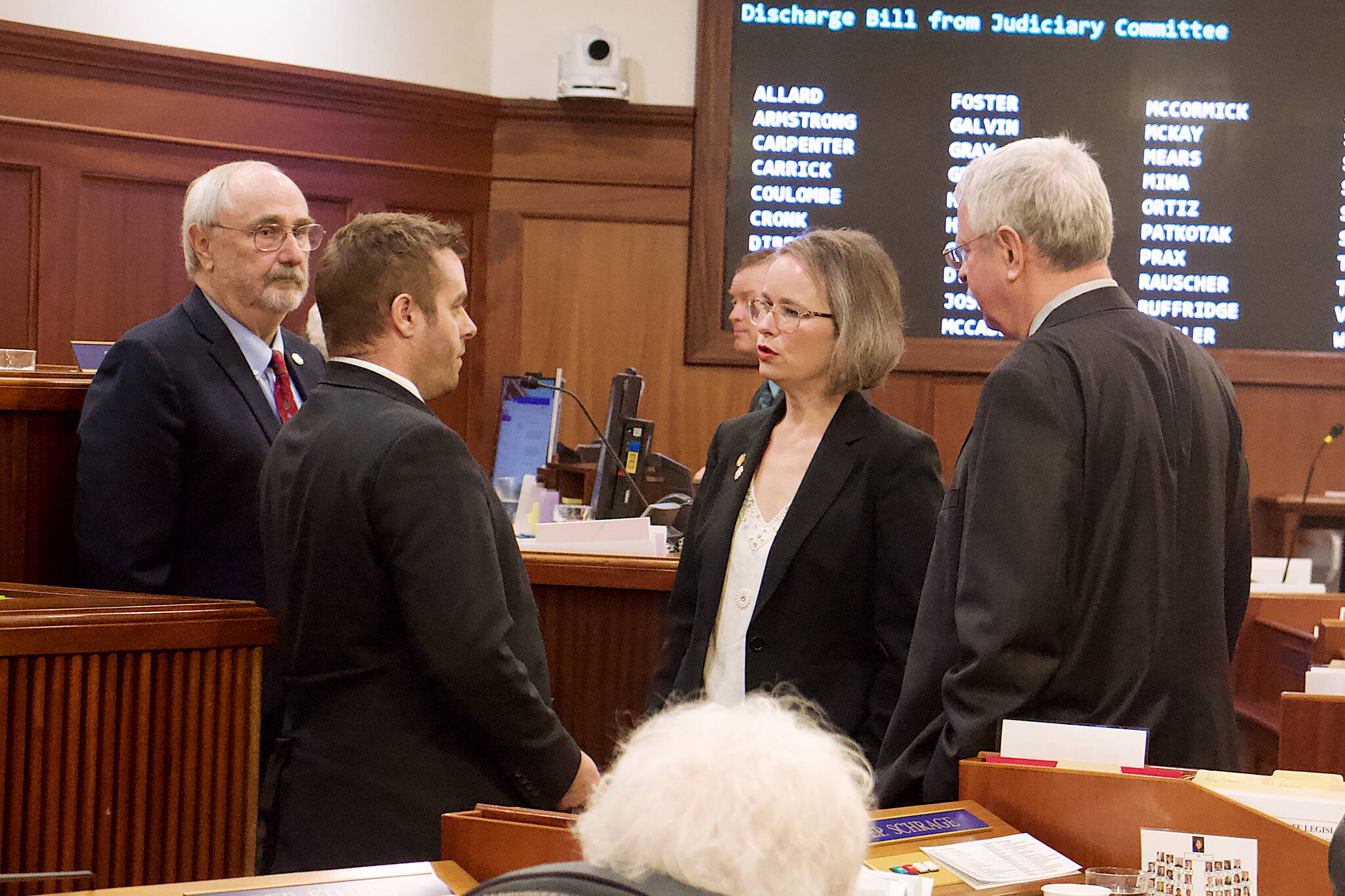 Rep. Sarah Vance, R-Homer, center, House Majority Leader Dan Saddler, R-Eagle River, right, and House Rules Chair Craig Johnson, R-Anchorage, talk to Rep. Jesse Sumner, R-Wasilla, about his request to have a bill discharged from the House Judiciary Committee chaired by Vance. The request was the second for a bill during Friday’s floor session, based on the belief Vance would not allow the bills to advance beyond her committee, following a floor vote when a bill she sponsored related to boycotts involving Israel failed by a 20-20 vote. (Mark Sabbatini / Juneau Empire)
