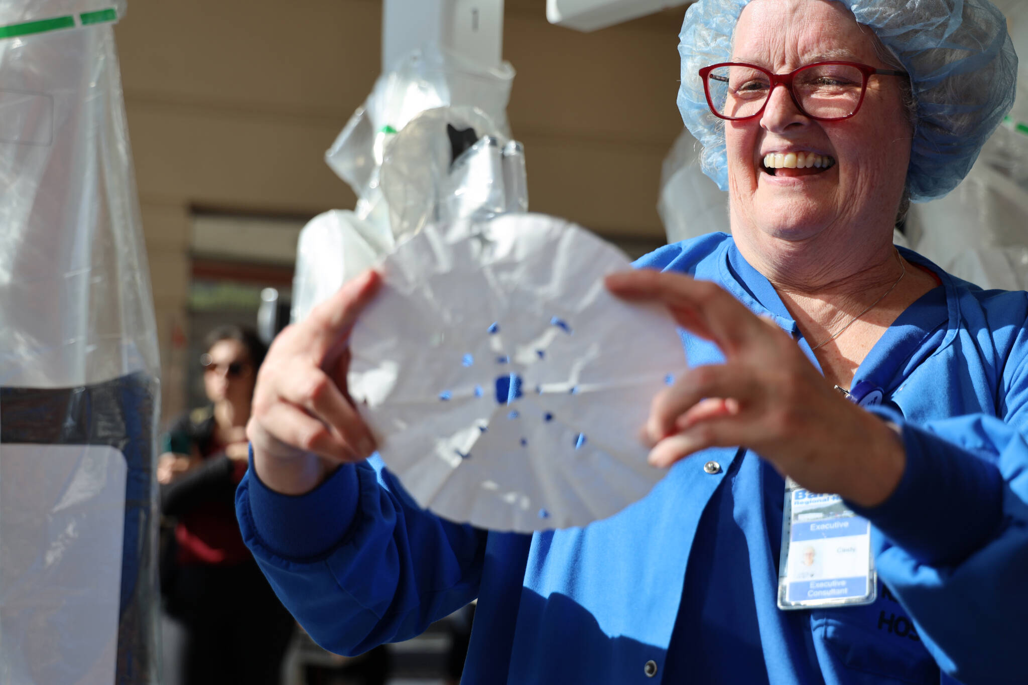 Cindy Spica, a private robotic consultant who traveled to Juneau to assist Bartlett Regional Hospital in preparing to use the new machine, smiles at a snowflake made by Thunder Mountain High School junior and exchange student from Brazil, Ana Scopel, using the Da Vinci Xi Robotic Surgery System. (Clarise Larson / Juneau Empire)