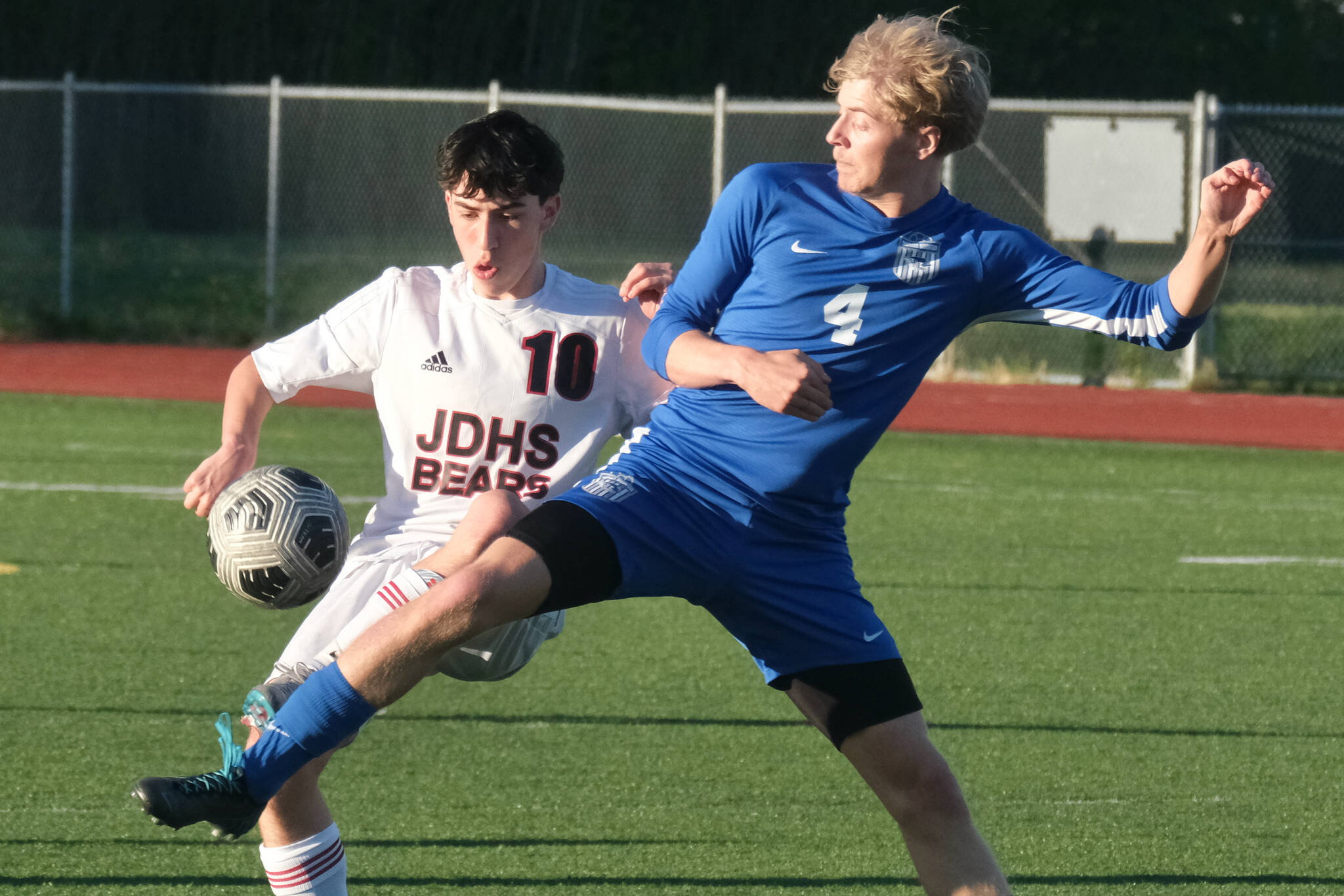 JDHS sophomore Kellen Chester (10) and TMHS senior Matthew Spratt (4) battle for a ball during the Crimson Bears 6-1 win over the Falcons Tuesday at Falcons Field. (Klas Stolpe / Juneau Empire)