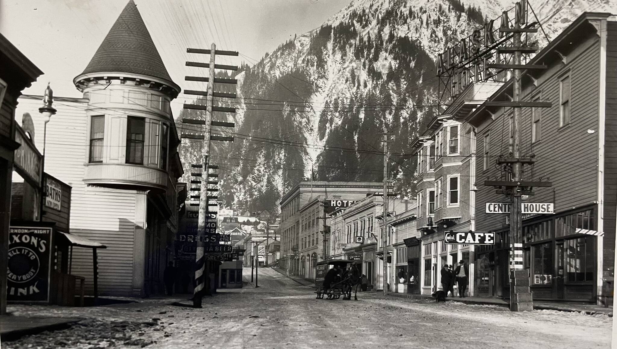 By 1914, when this photo was taken, Juneau had developed into an established city. The Victorian era turreted Alaska Steam Laundry (built 1901) is seen on the left, while other buildings such as the Alaskan Hotel and Central Rooming House are on the right. The rooming house was reconstructed in the 1980s. It is now the Senate Mall. (Alaska State Library-P31-021).