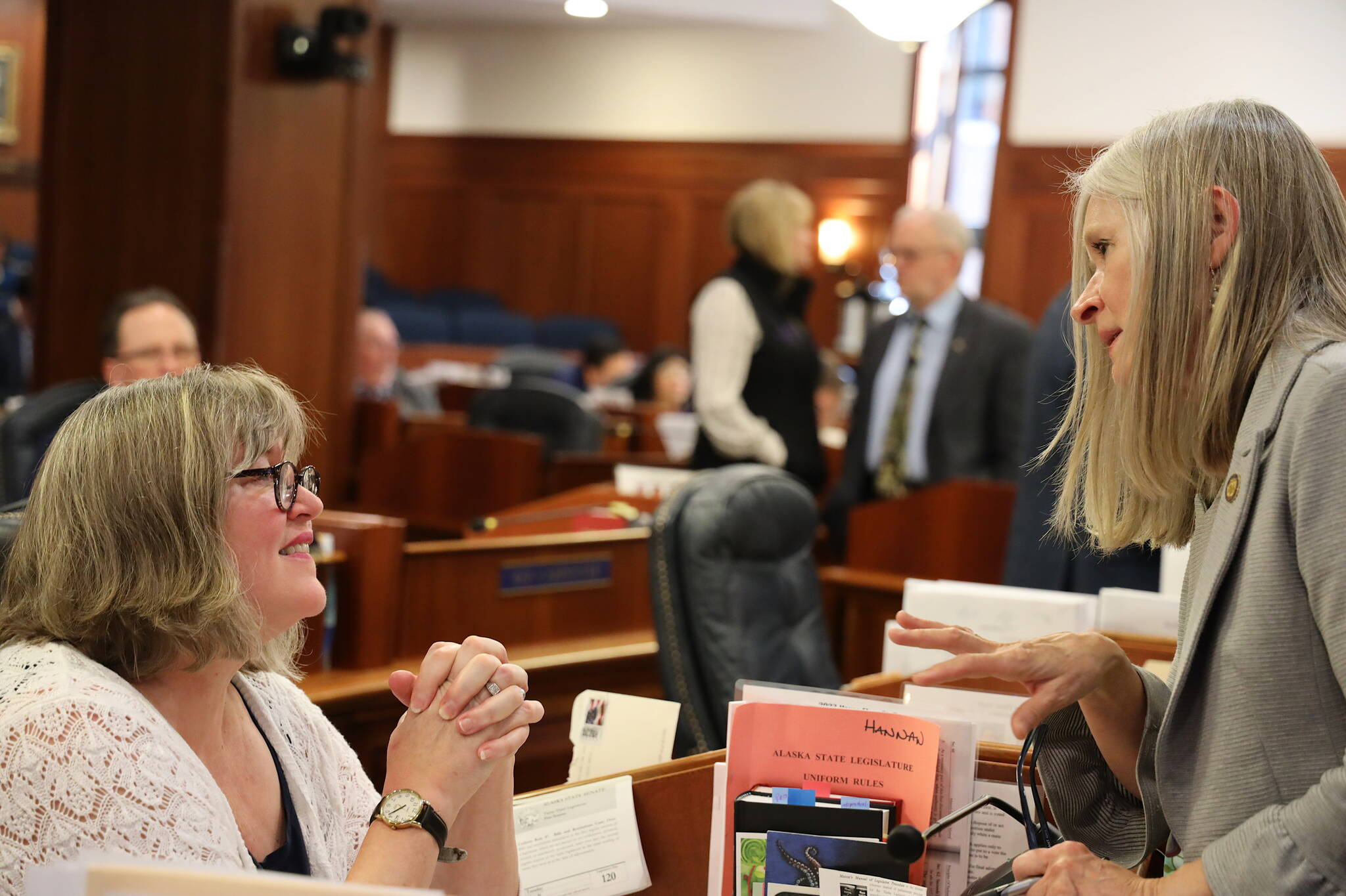 Juneau state representatives Sara Hannan, left, and Andi Story discuss legislative business during a break in the House floor session on Tuesday. Both Democratic members were part of the minority caucus this session after being in the majority during their first two terms. (Clarise Larson / Juneau Empire)