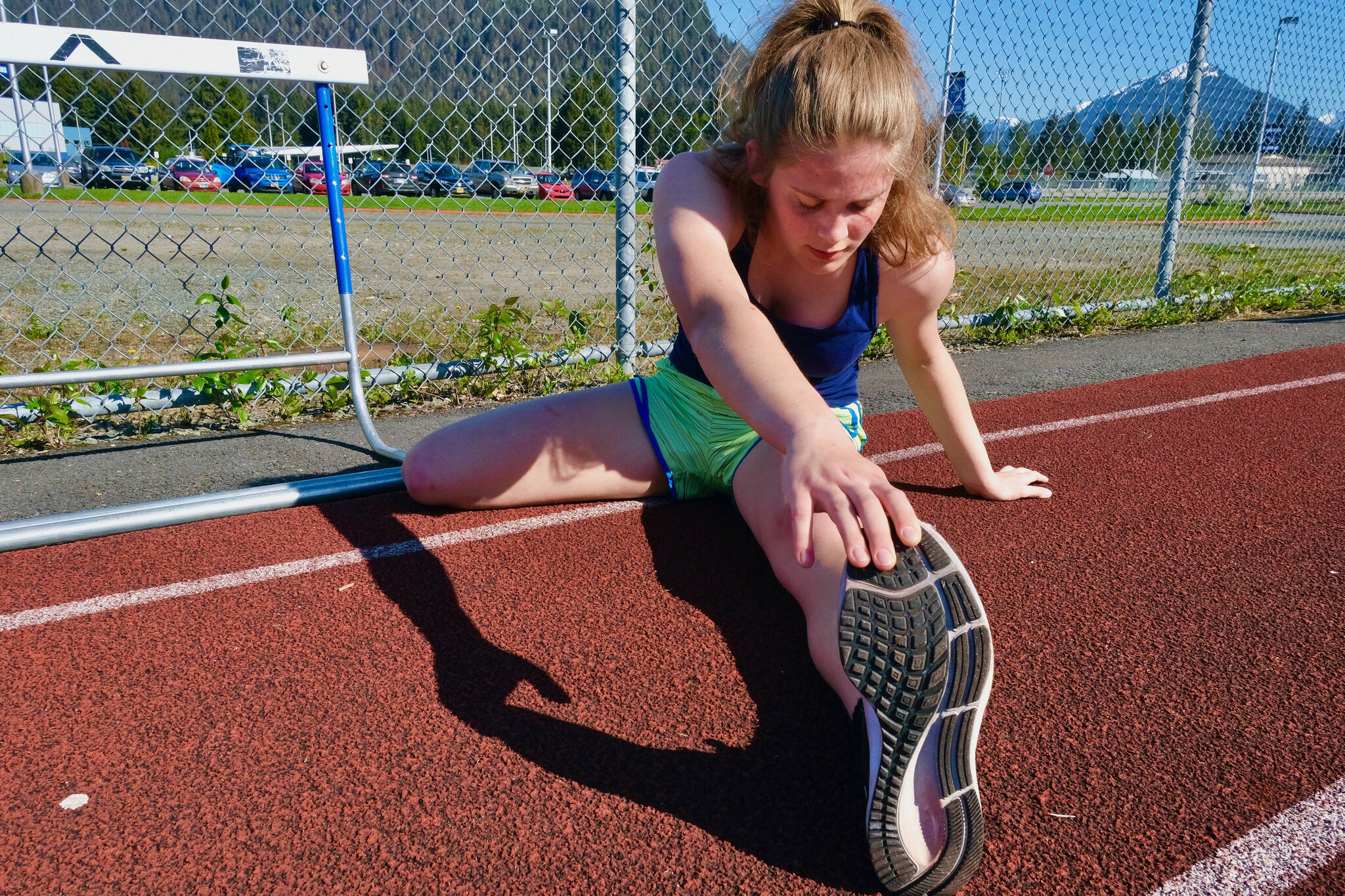 Thunder Mountain High School senior Mallory Welling stretches before a Falcons track practice on Wednesday. The Region V Track & Field Championships are Friday and Saturday at Falcons Field. (Klas Stolpe / Juneau Empire)