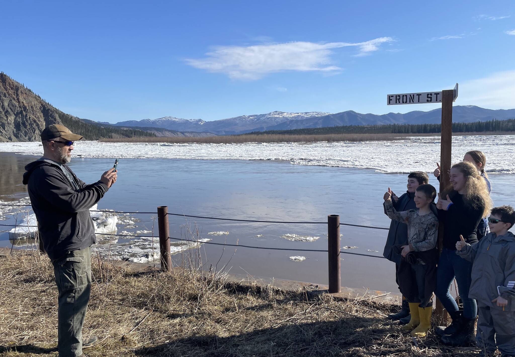 Ryan Becker, a teacher at the Eagle school, takes a photo of his students as part of a continuing Yukon River ice study on May 12, 2023. (Courtesy Photo / Ned Rozell)