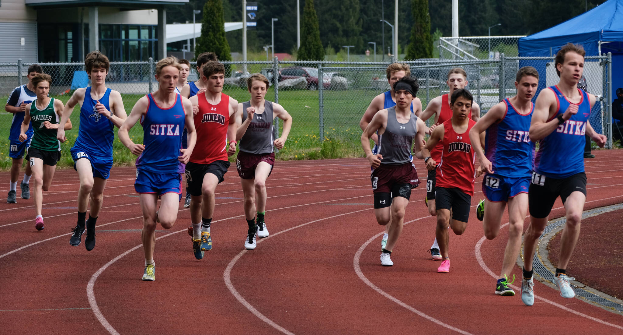Runners round the first turn in the boys combined DI/DII 3200 meters during the Region V Track & Field Championships, Friday, at Thunder Mountain. The championships resume Saturday. (Klas Stolpe / Juneau Empire)