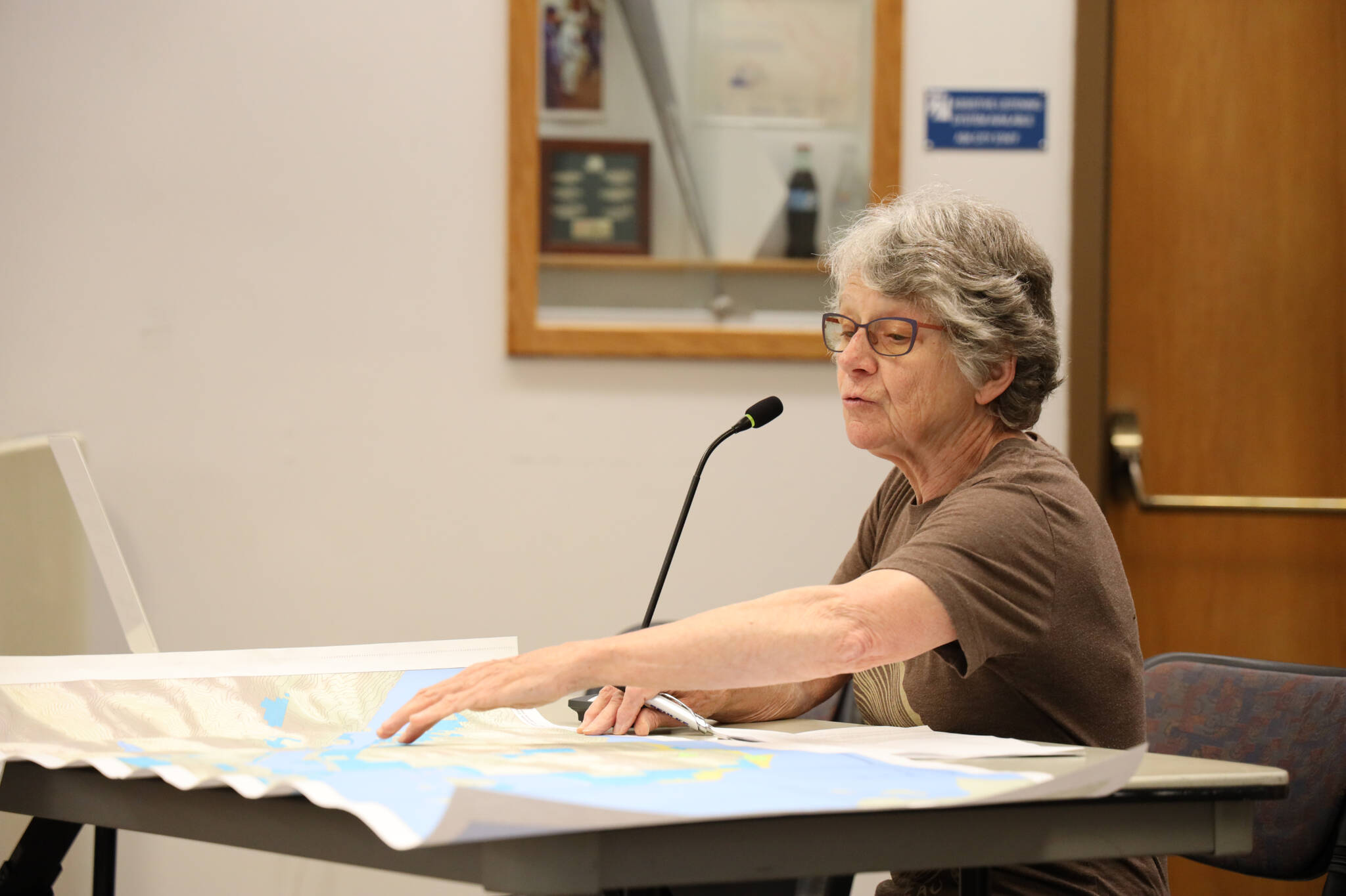 Nancy Waterman point to a map of Juneau and Douglas during an open forum about a second crossing between the Juneau mainland and Douglas Island hosted by the City and Borough of Juneau Public Works and Facilities Committee Thursday evening. (Clarise Larson / Juneau Empire)