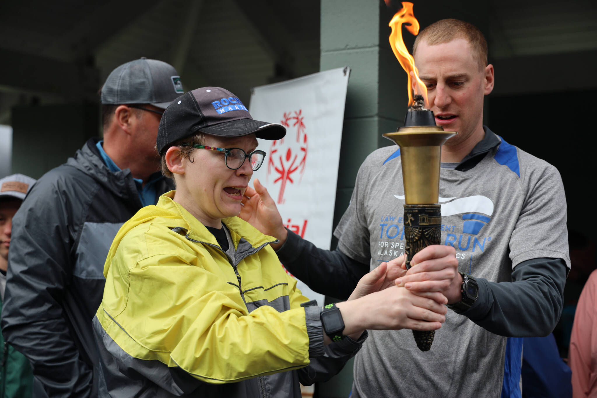 Athlete Tammy Birch carries the torch with help from Branden Forst during the Alaska Law Enforcement Torch Run at Twin Lakes Park Saturday morning. (Clarise Larson / Juneau Empire)