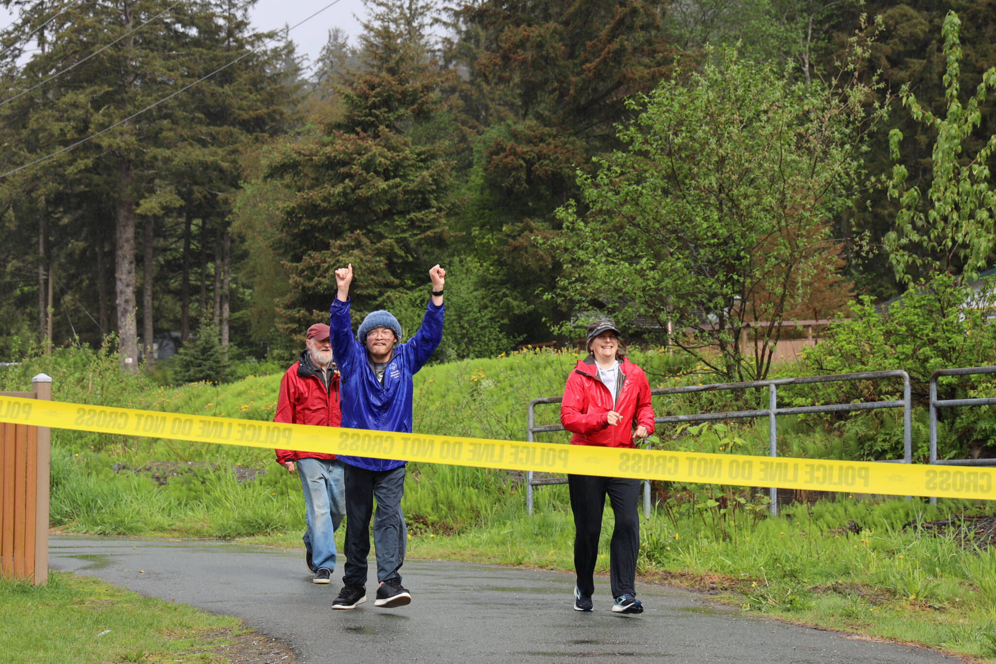 Fu Bao Hartle celebrates before crossing the finish line alongside Clare Pavia during the Alaska Law Enforcement Torch Run at Twin Lakes Park Saturday morning. (Clarise Larson / Juneau Empire)